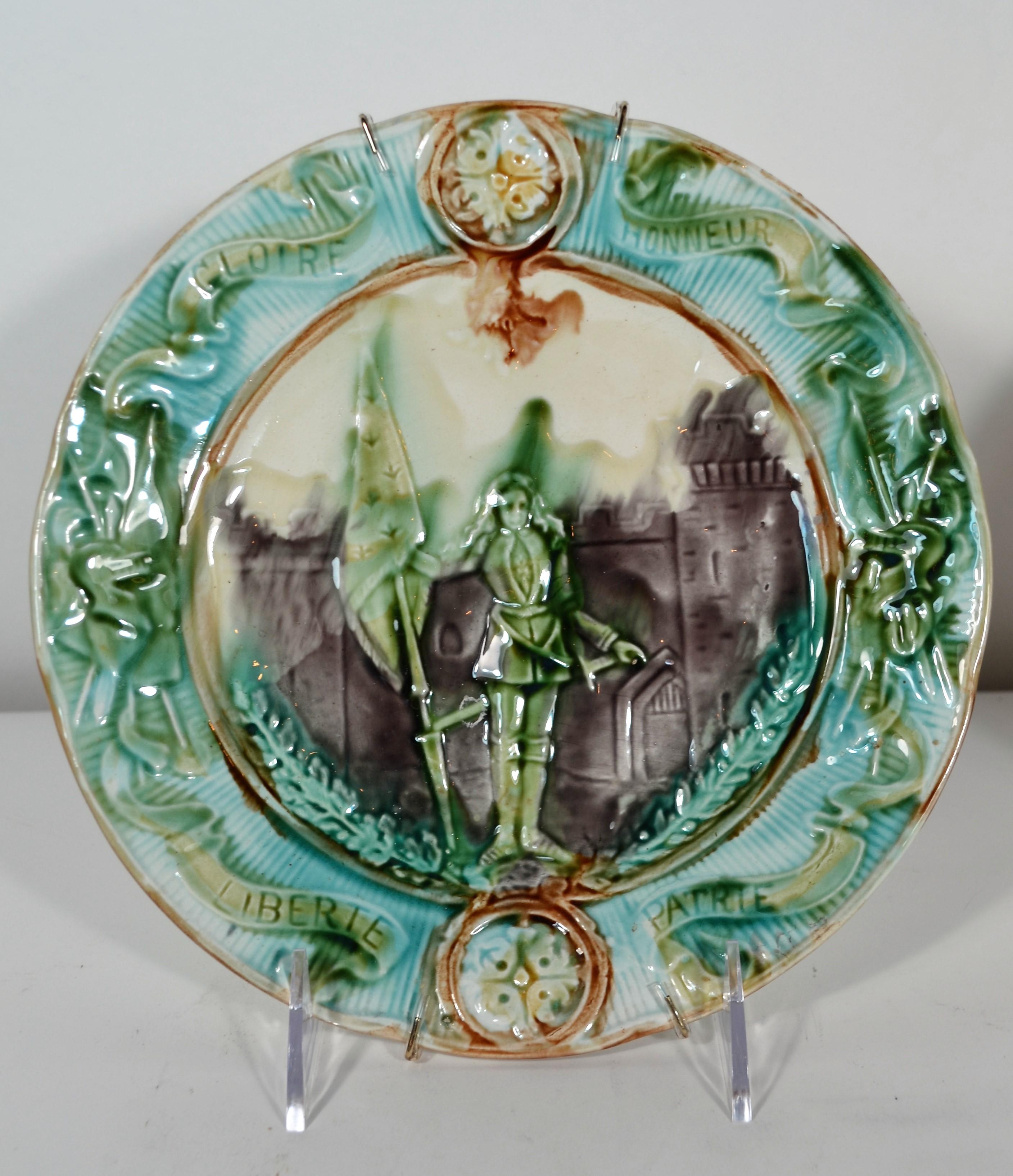 Each plate is inscribed with the words Glorie, Honneur, Liberte, Patrie surrounding the figure, who appear to be Joan of Arc. Very pretty jewel tone colors are used on these plates. 