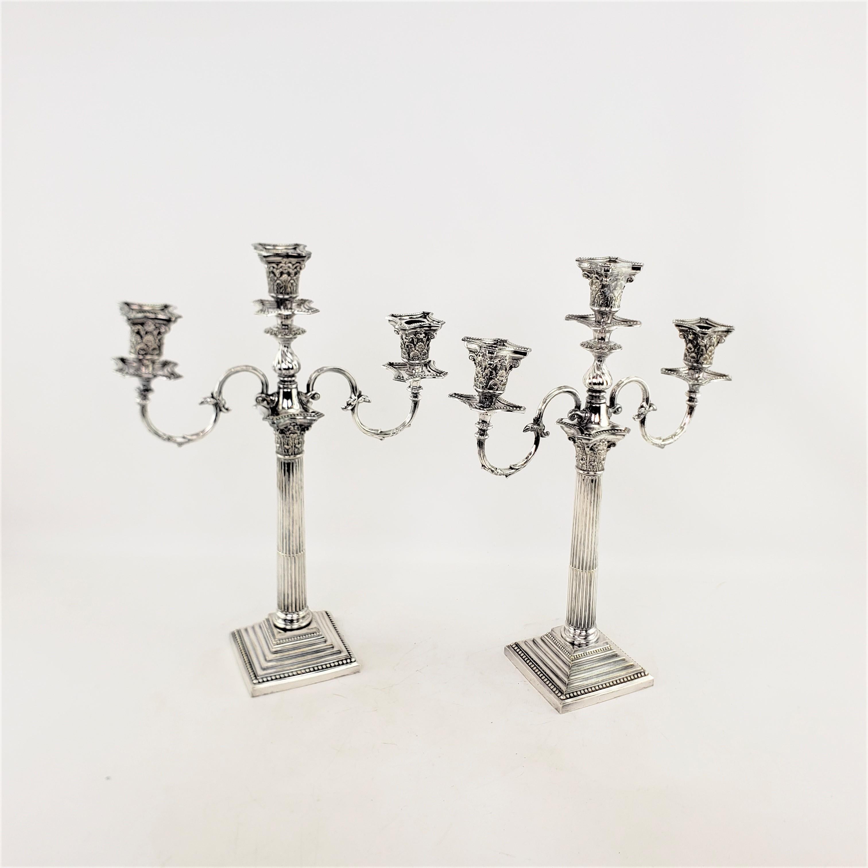 This pair of antique convertible candelabras were made by the well known Mappin & Webb of England in approximately 1920 in a Classical Greek Revival style. These candelabras are composed of silver plate and are ornately cast with an Ancient Greek