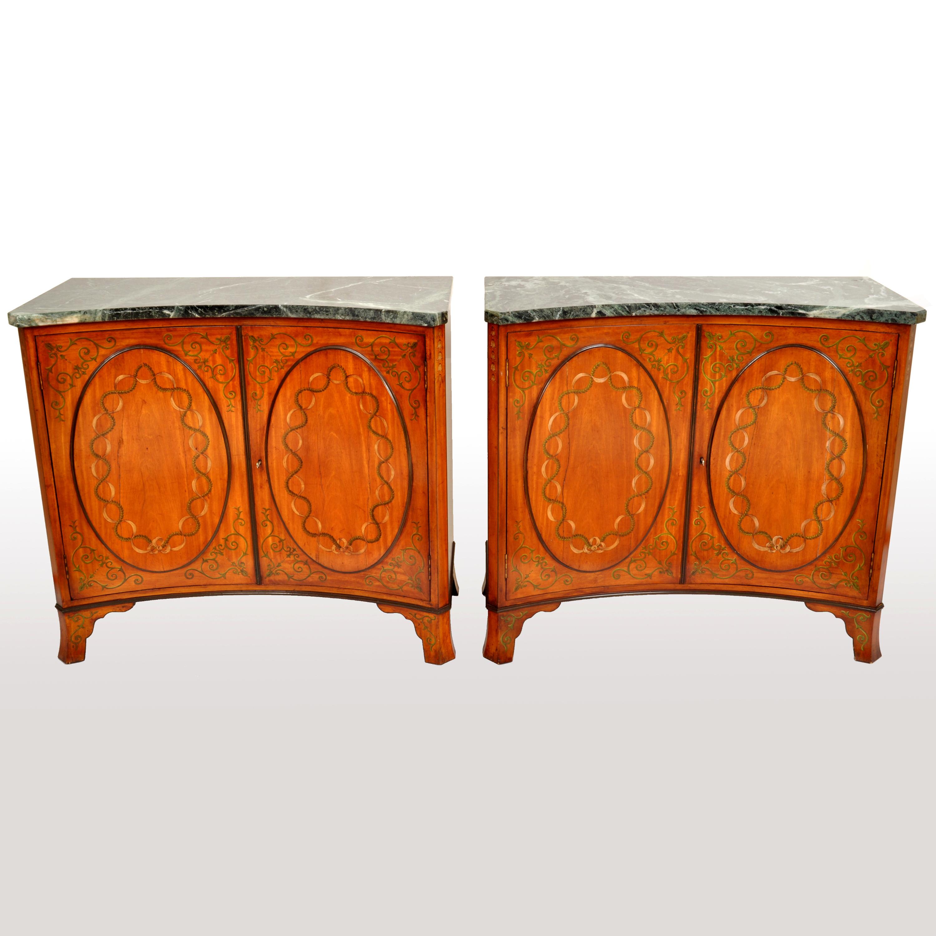 A pair of fine & rare antique Adam Revival satinwood & marble top side cabinets, circa 1880.
The cabinets of concave form and having green & white variegated marble tops, each cabinet with twin doors with oval paterae having painted decoration and