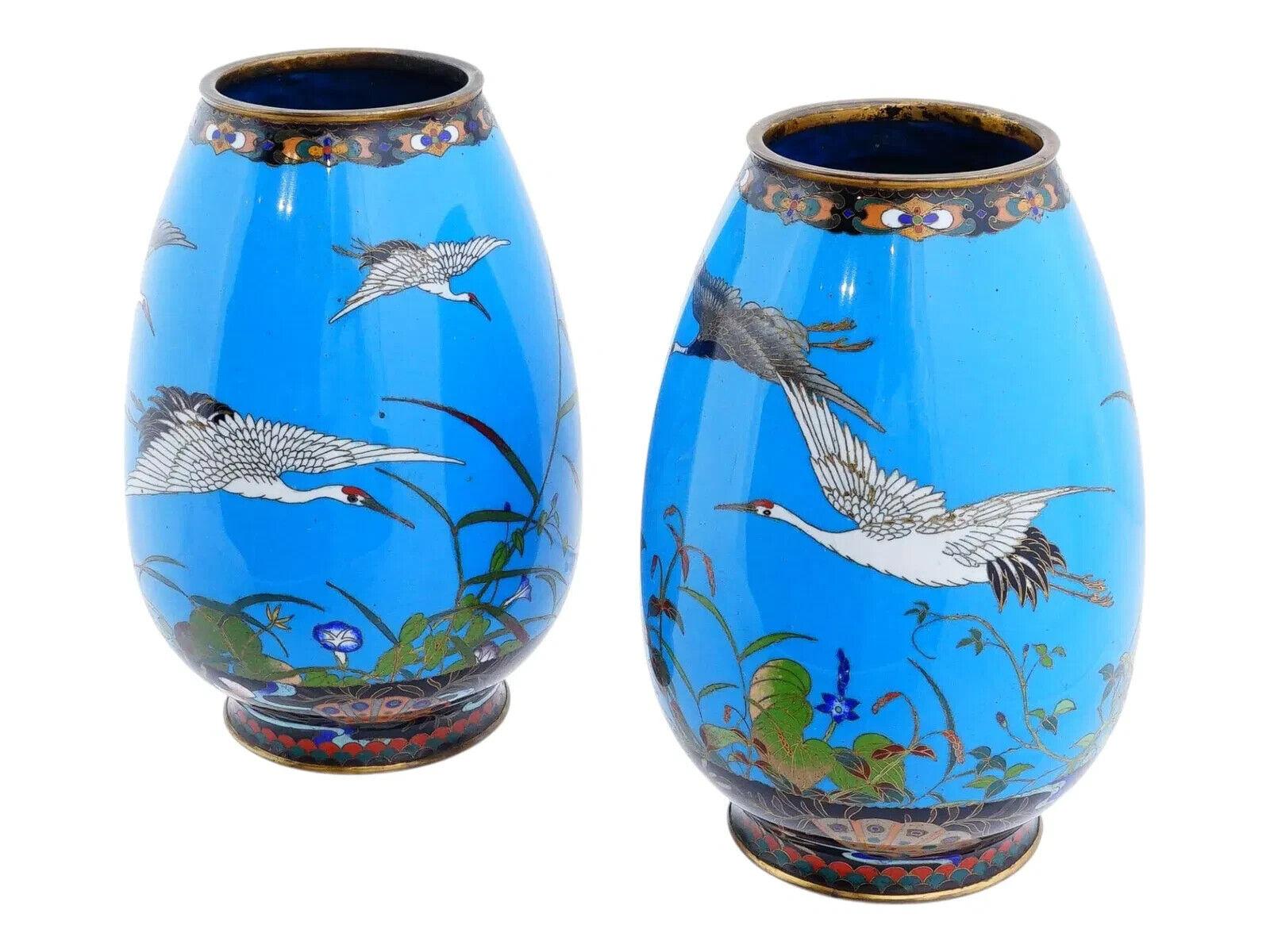 Coppia di antichi vasi giapponesi in cloisonne del periodo Meiji. Ognuno di essi è adornato con immagini di gru e splendidi motivi floreali multicolori all'interno di intricati motivi fogliati, tutti abilmente intrecciati con delicate perline su