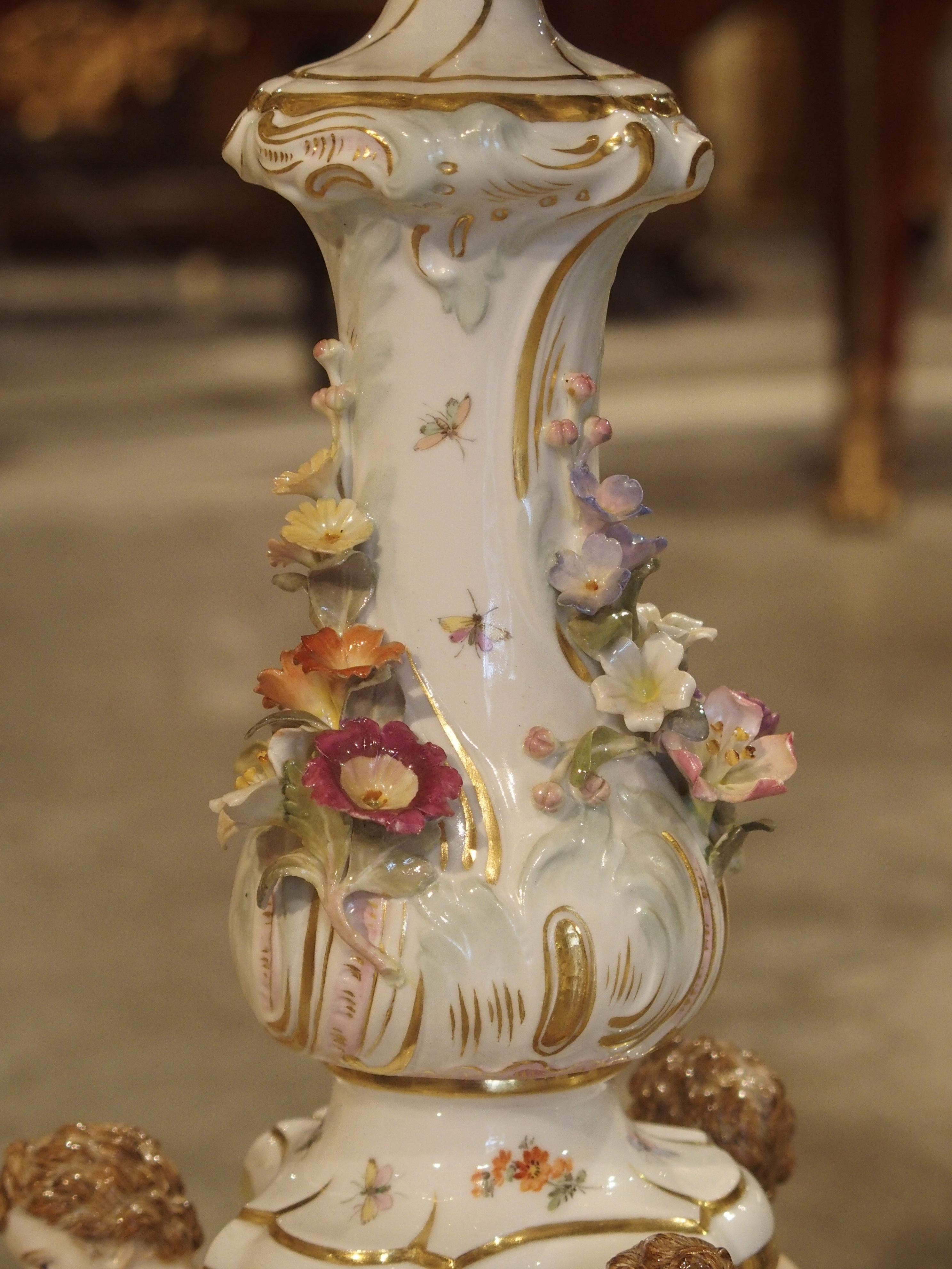 This elegant pair of colorful German Meissen, seven-arm candelabras dates to the early 1900s. The gros relief intricacy and thinness of the porcelain flower heads, leaves and fruit is absolutely astounding. There are flat paintings of ladybugs,
