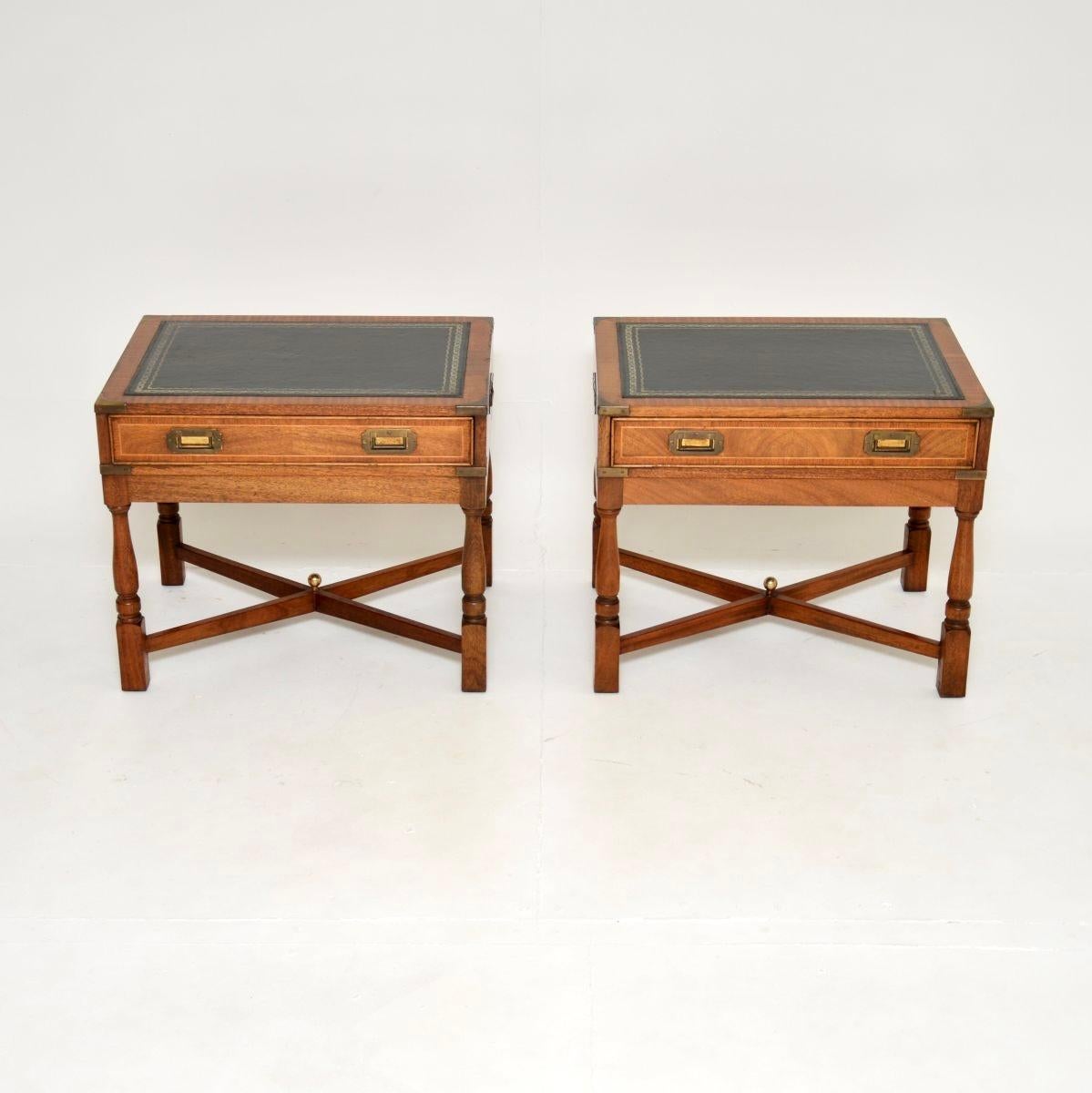 Une paire de tables d'appoint de style campagne militaire antique, élégante et très bien faite. Ils ont été fabriqués en Angleterre et datent des années 1950.

La qualité est fantastique, la taille est très utile et les dossiers sont polis, ce qui