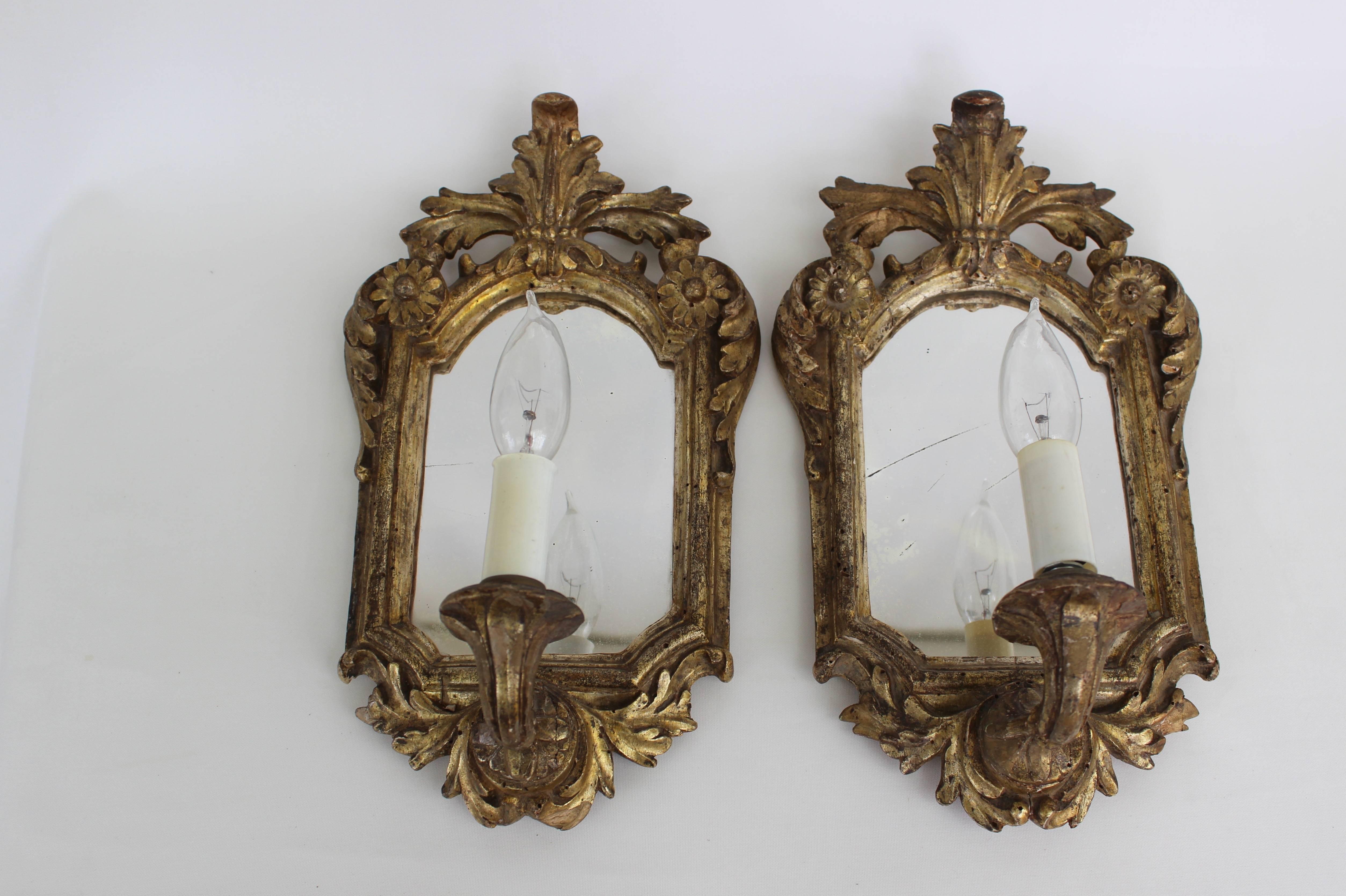 Pair of antique mirrored and electrified gilded wood sconces.