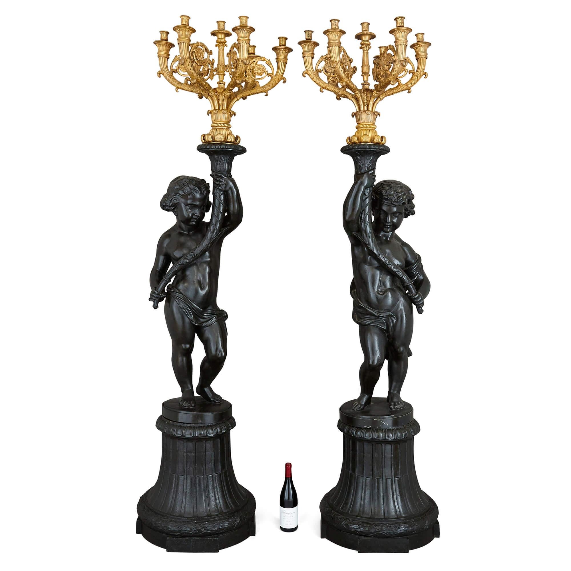 Pair of antique monumental cast iron and gilt bronze candelabra
French, late 19th Century
Height 219cm, width 52cm, depth 52cm

This exceptional pair of monumental candelabra is designed in the elegant Neoclassical style. Each candelabrum in the