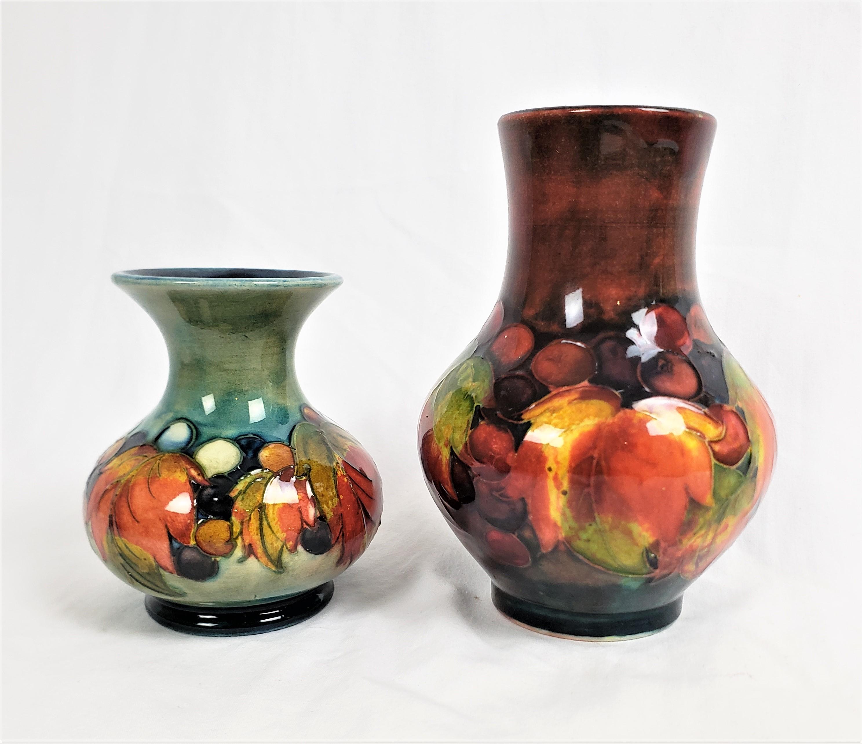 This pair of art pottery vases were done by the renowned Moorcroft Pottery Co. of England in approximately 1920, in their period Art Deco style. These vases are decorated with the Moorcroft 