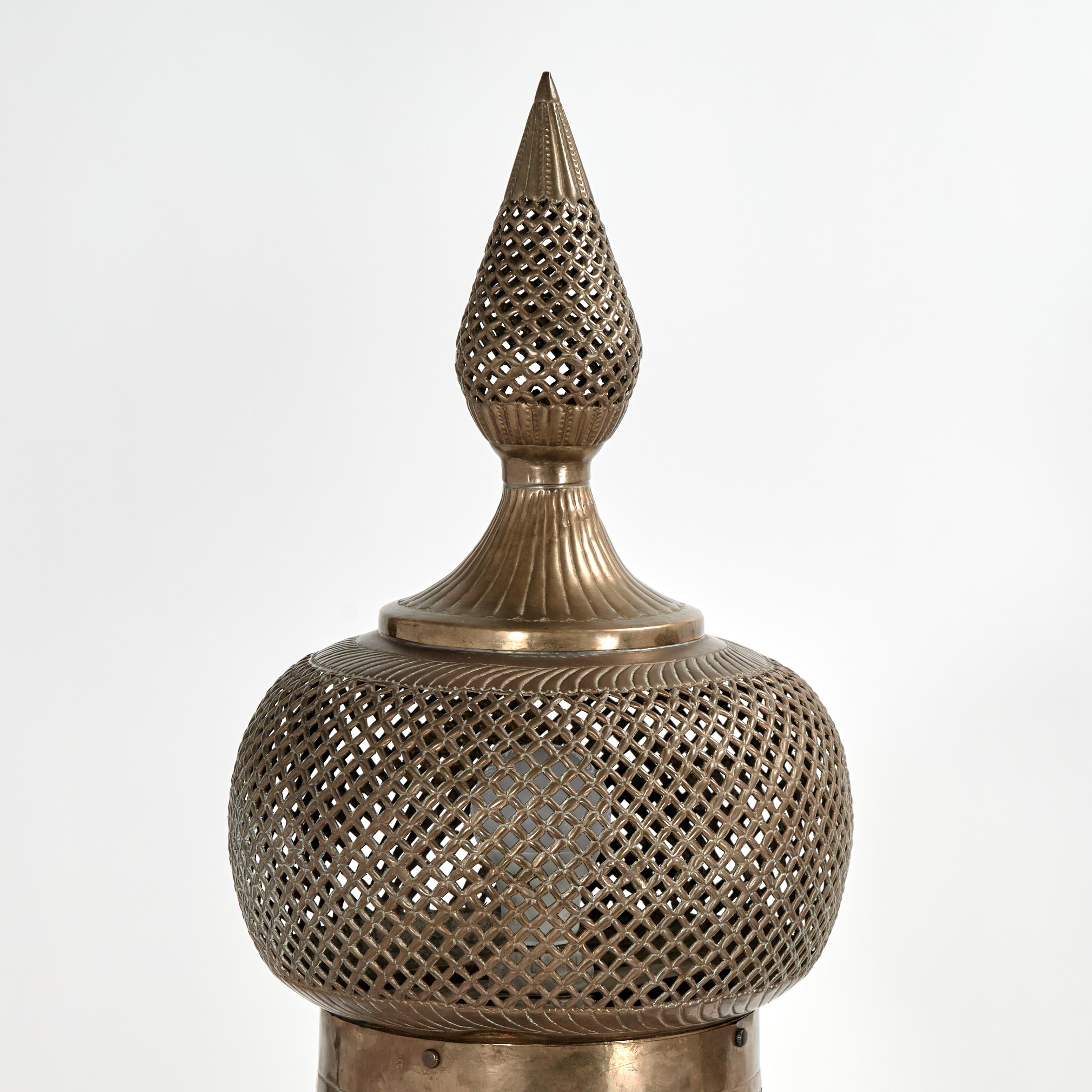 Paire de lampadaires marocains anciens, fabriqués à la main en laiton perforé avec des motifs floraux martelés dans une forme mauresque dramatique sur des pieds en forme de pattes stylisées. 