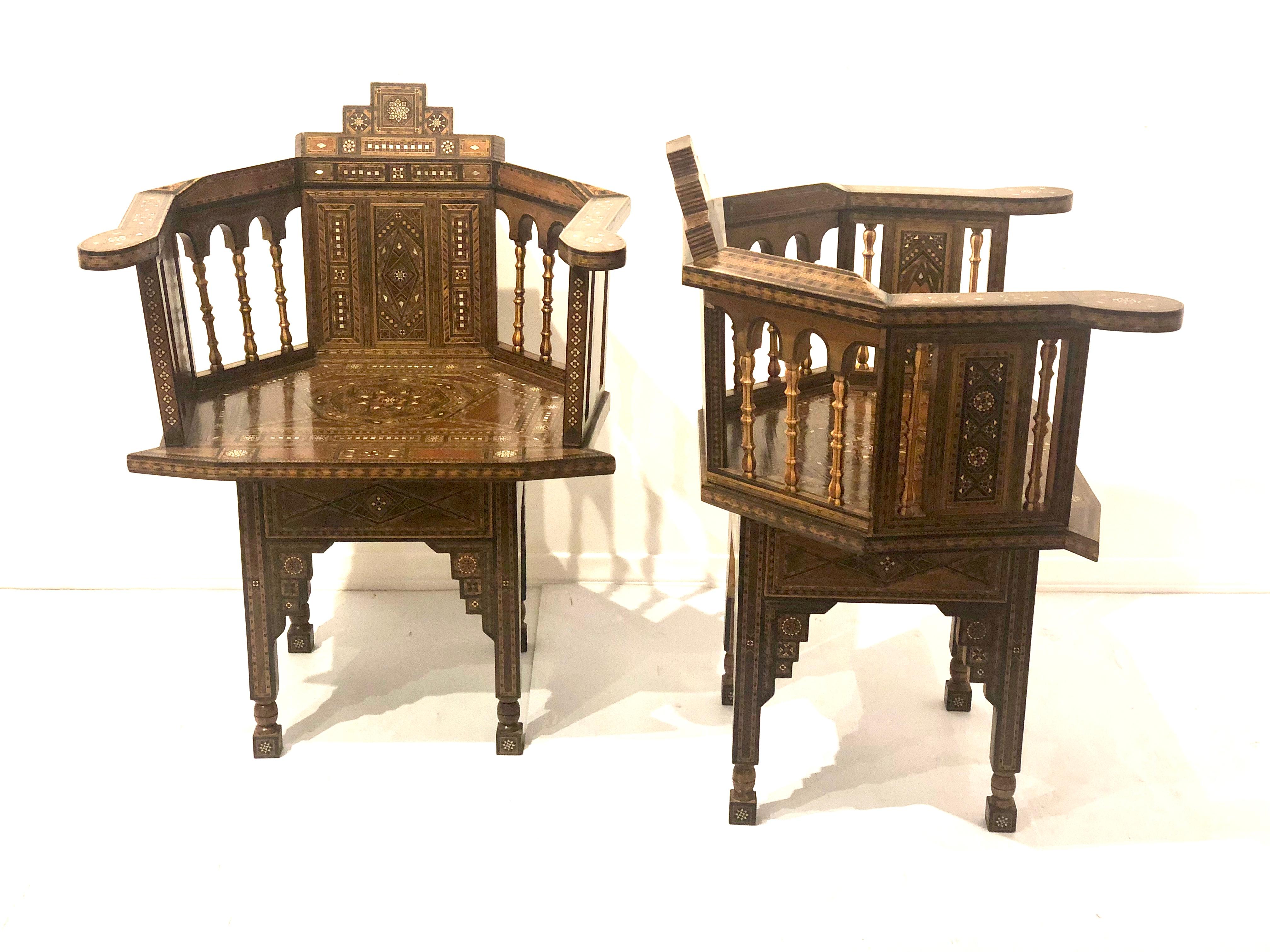 A pair of Syrian barrel back chairs with geometric lines and exotic wood inlays with mother of pearl detail. Sometimes referred to as Moroccan. We think these pair its early 20th century with a mix of woods, these chairs are impressive and a piece