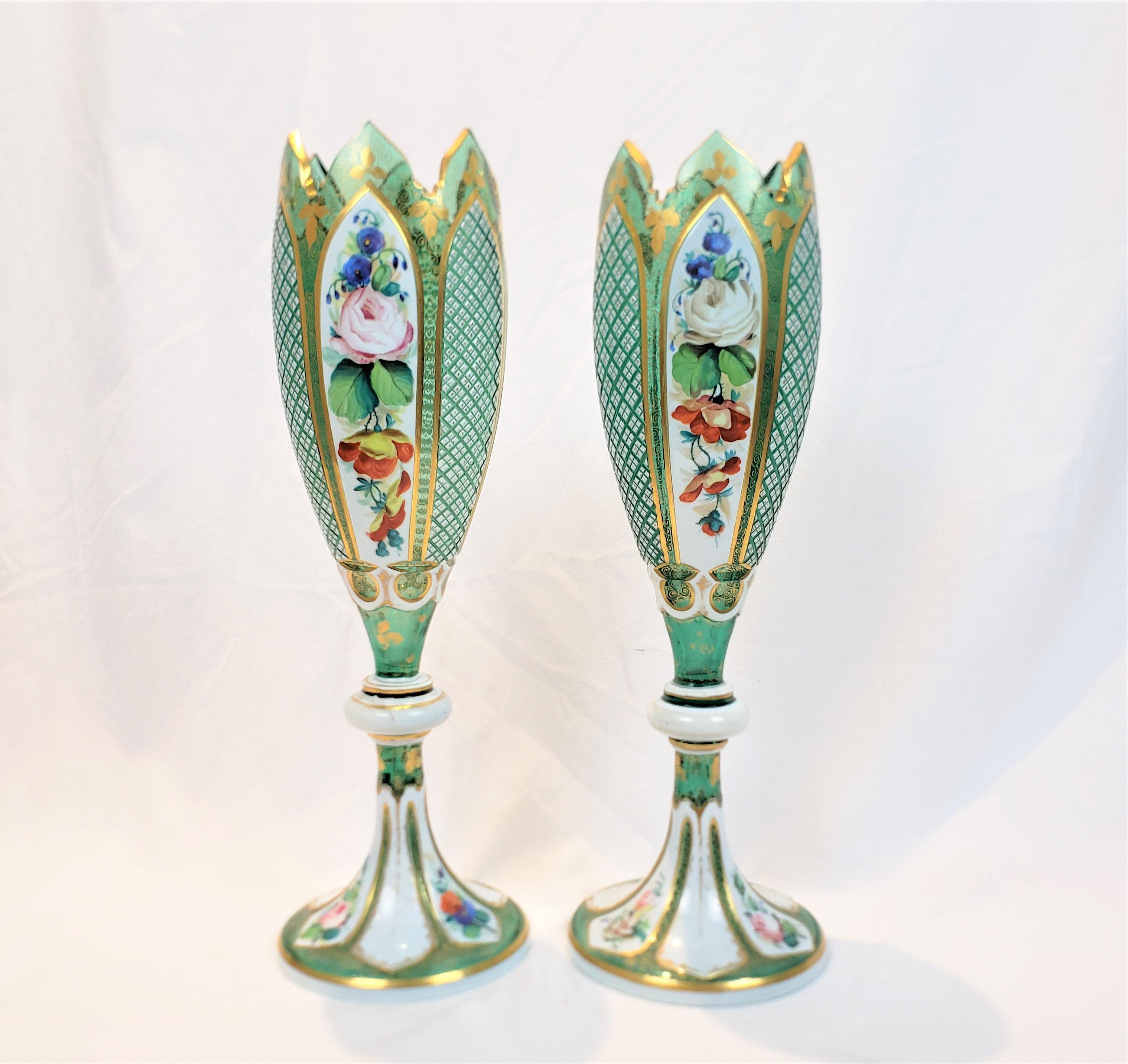 This pair of antique vases are unsigned, but presumed to have originated from Bohemia, now the Czech Republic and date to approximately 1880 and done in the Carl Moser style. The vases are composed of a deep green glass with fluted sides and cut