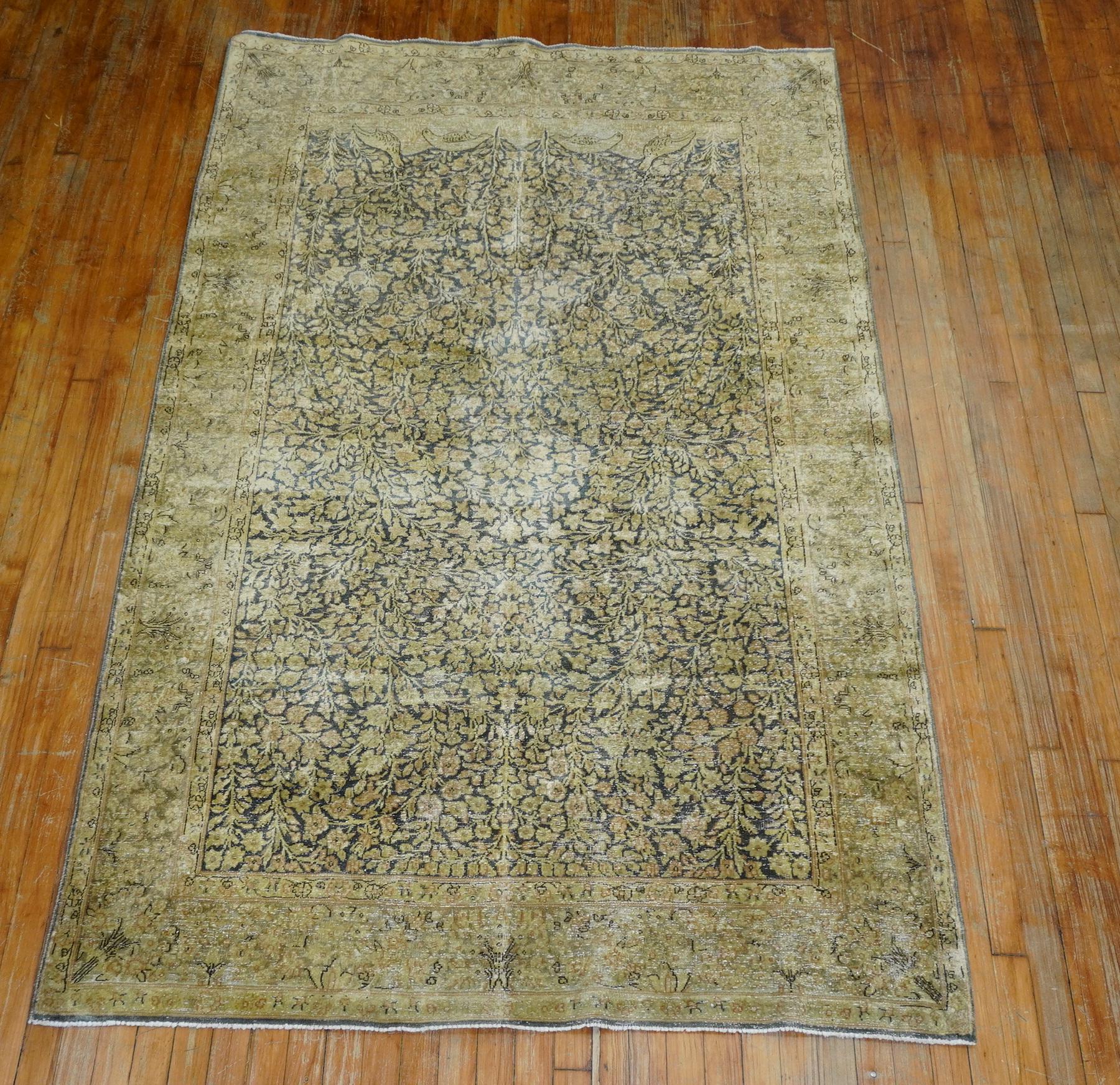 Matching pair of early 20th century antique Persian Kerman rugs with one measuring 4'11” x 8” and the other measuring 4'9” x 8'2”. Both pieces have wear and come off in green and gold hues.