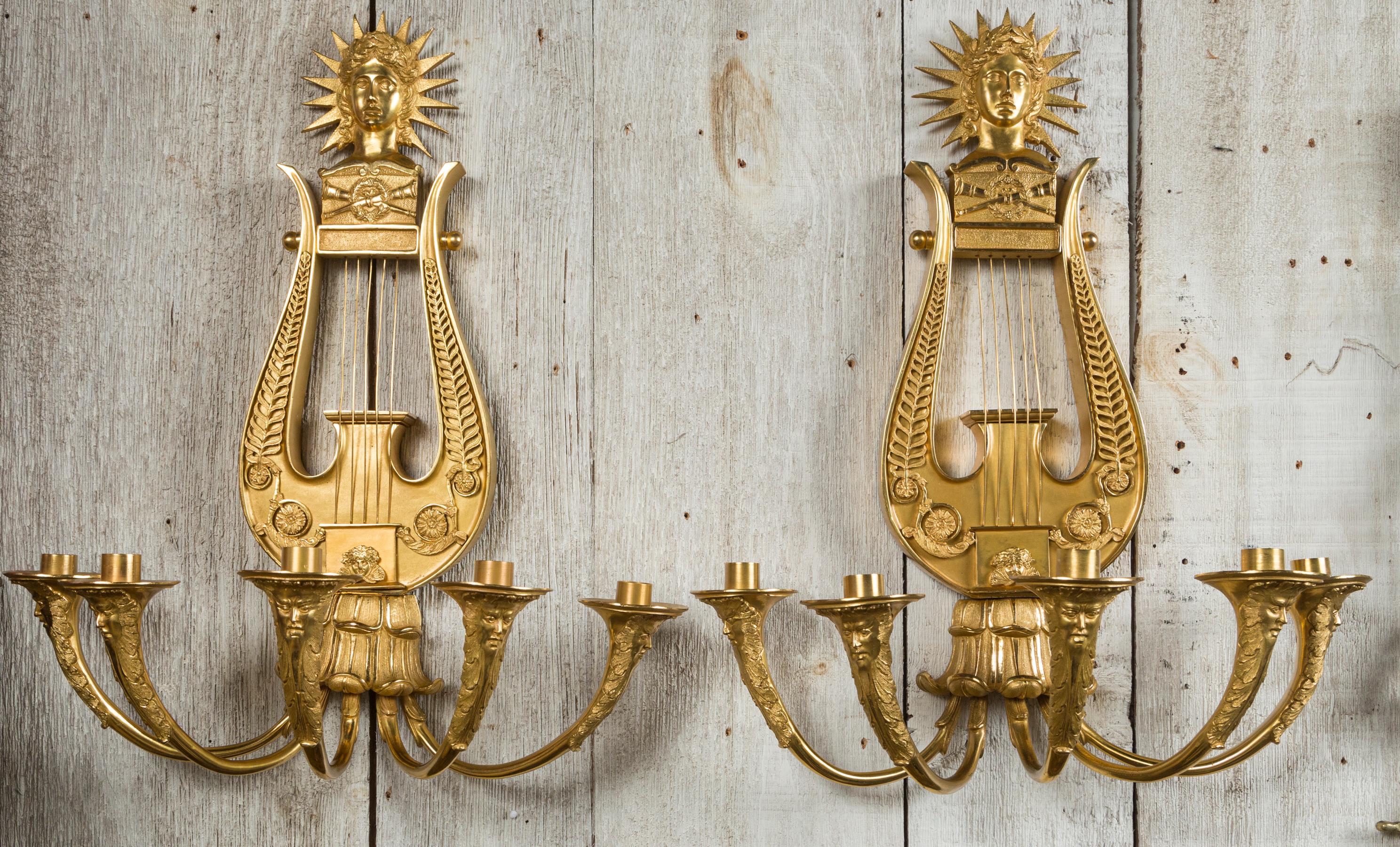 Dating from the early part of the 19th century, they have been regilded. Best quality of casting, carving and chasing. Excellent regilding by a New York company.
Five candle arms, with faces carved and chased. Lyre form above, with their strings.