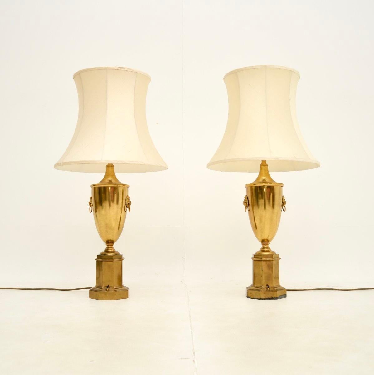 Une superbe paire de lampes de table antiques en laiton néoclassique. Fabriqués en Angleterre, ils datent des années 1930.

La qualité est exceptionnelle, les pieds de lampe en laiton massif ont un magnifique design en forme d'urne avec des poignées
