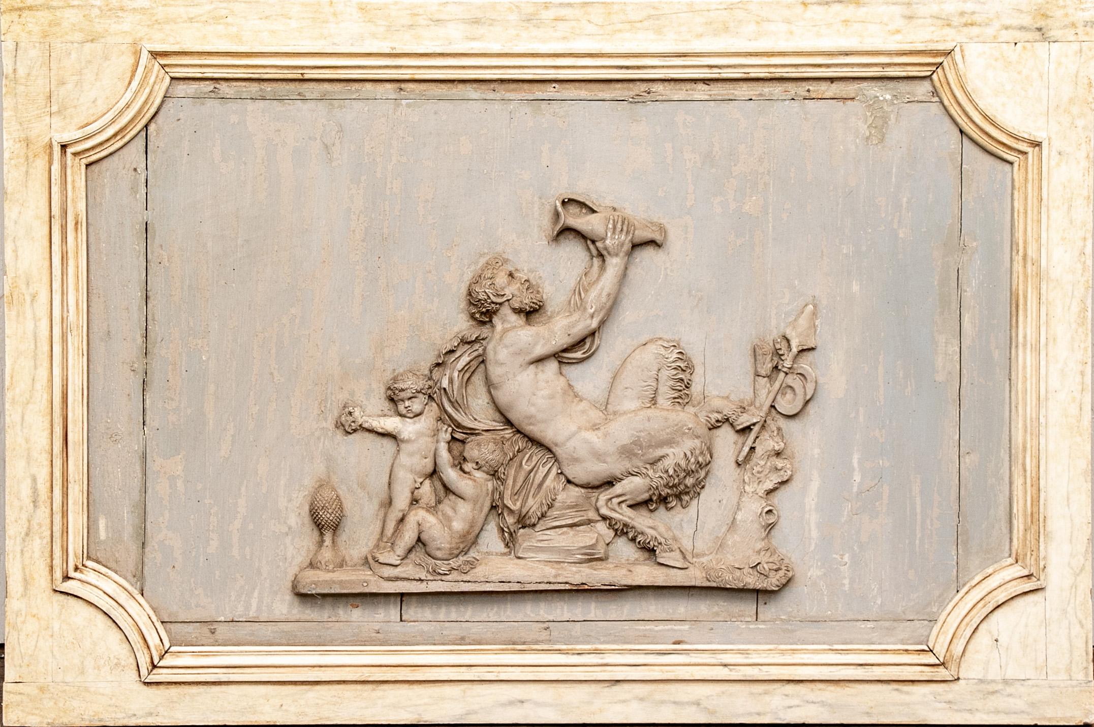 Rare and decidedly spectacular early pair of neoclassical plaques. One having a carved and painted Bacchic relief plaque with putti joining Pan drinking from a jar. The antique plaques mounted in pale yellow faux marble painted wood frames.
The