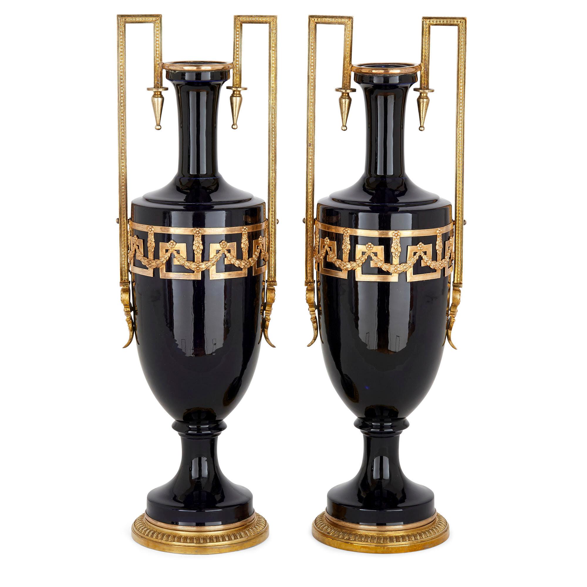 Pair of antique neoclassical style faience and gilt metal vases
French, circa 1900
Measures: Height 48cm, width 15cm, depth 12cm

These fine blue faience and gilt metal vases might take stylistic inspiration from the vases of Ancient Greece, but