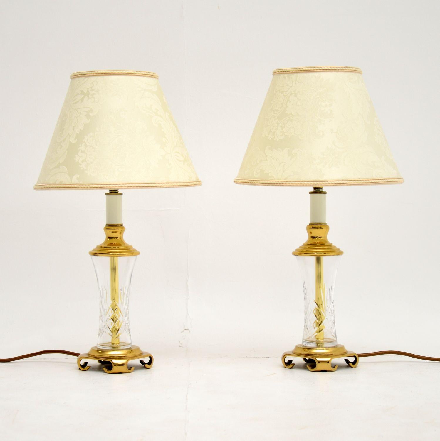 A beautiful pair of table lamps, in the antique neoclassical style. These date from around the mid-20th century.

They are of fine quality, and are made from beautiful etched crystal glass with solid brass bases and supports. They have lovely