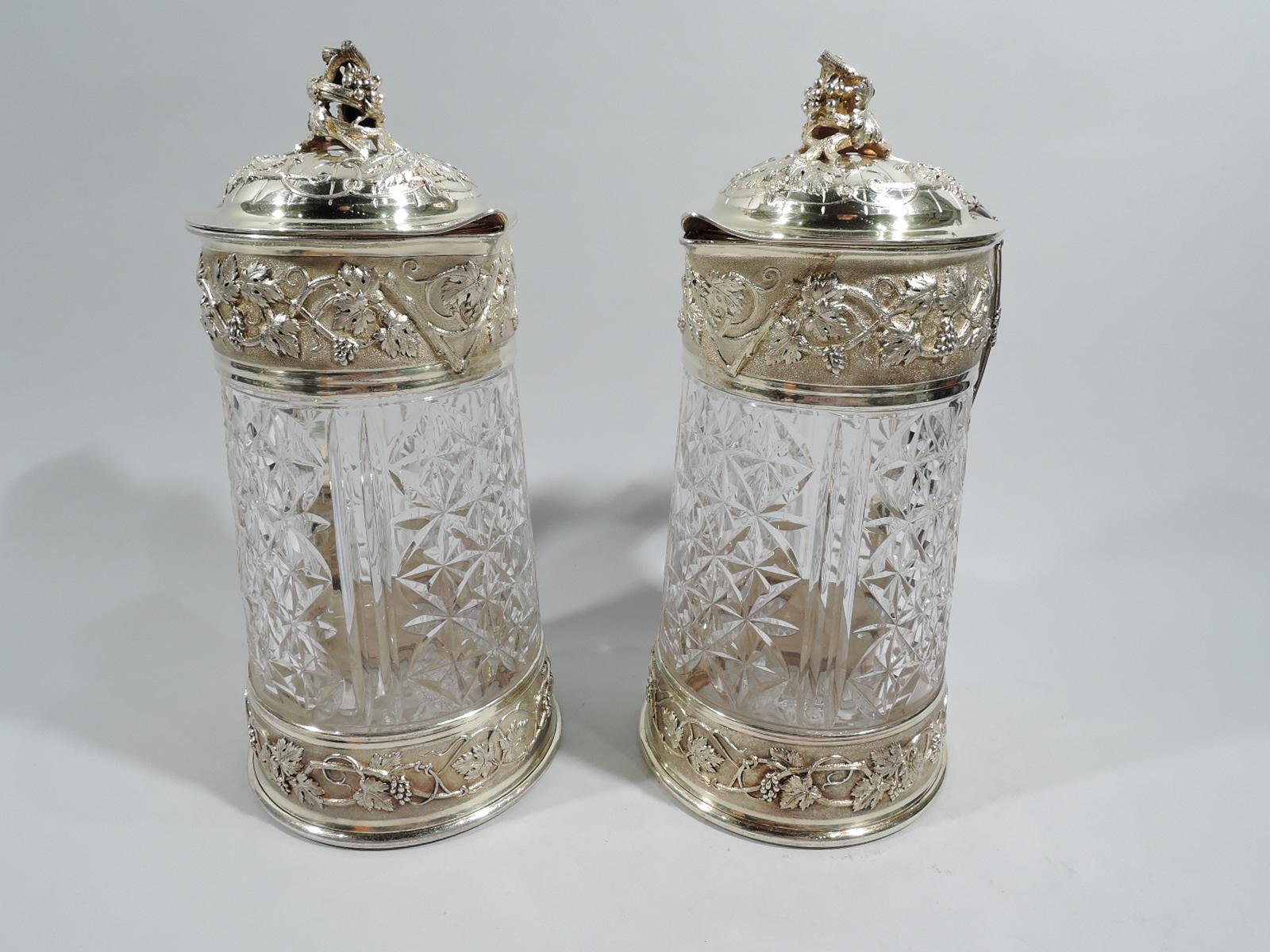 Pair of Belle Epoque cut-glass and gilt 950 silver decanters. Made by Odiot in France, ca 1880. Gently upward tapering body with alternating double flutes and paterae set in silver-gilt bands with chased fruiting grapevine. Scrolled handle and
