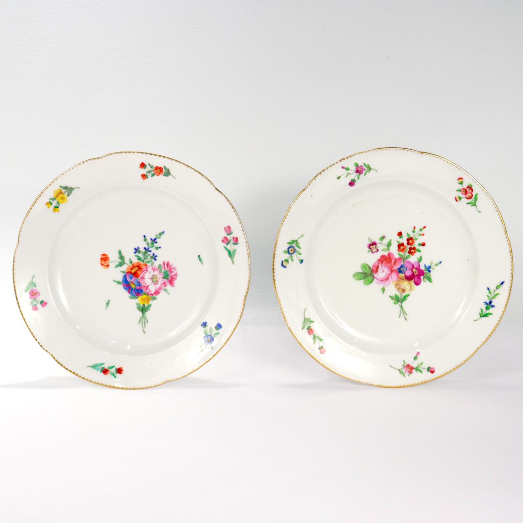 A fine pair of antique French porcelain plates.

In old Paris or vieux paris porcelain.

By the Paris porcelain manufactory of Peter Anton Hannong. 

With a scalloped border, gilt rim, and handpainted floral sprays throughout. 

Marked to the base