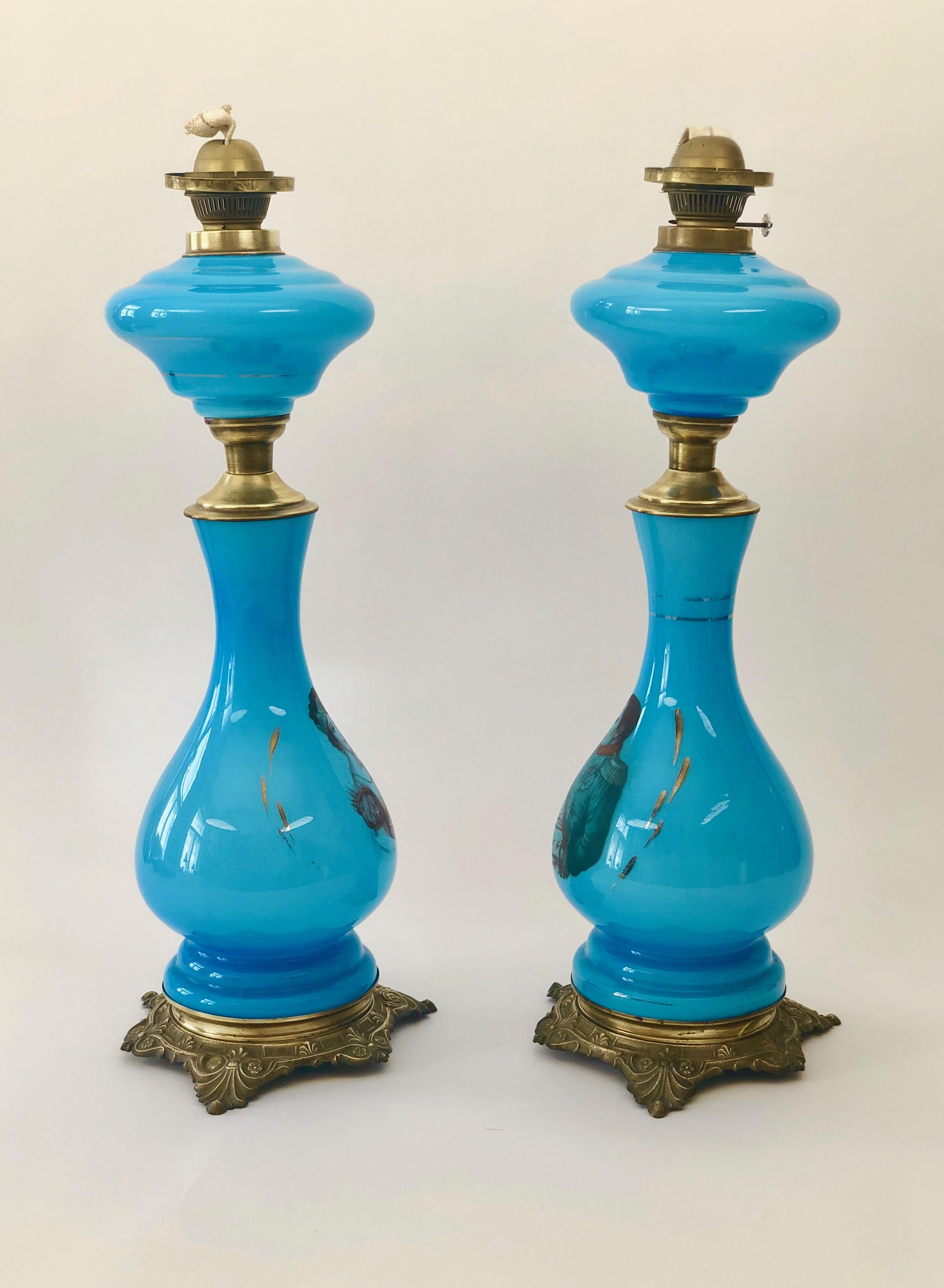 These French antique oil lamps are fitted with solid brass bases. Resting on the base are blue opaline glass elements. They are depicted with images of Napoleon and Josephine.

The lamps were designed in France during the latter half of the 19th