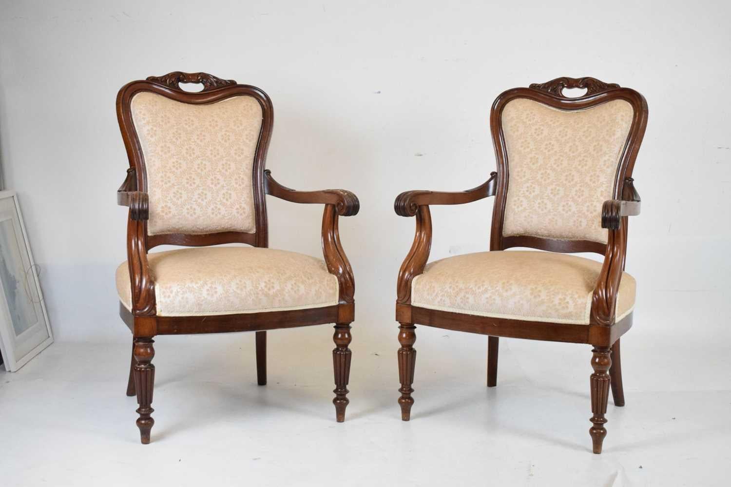 An elegant matching pair of mahogany open armchairs, scrolling shaped arms, on fluted turned supports, re-upholstered in cream damask fabric.
The open armchair and the fluted leg was modelled after ancient Greek columns, and it flourished in the