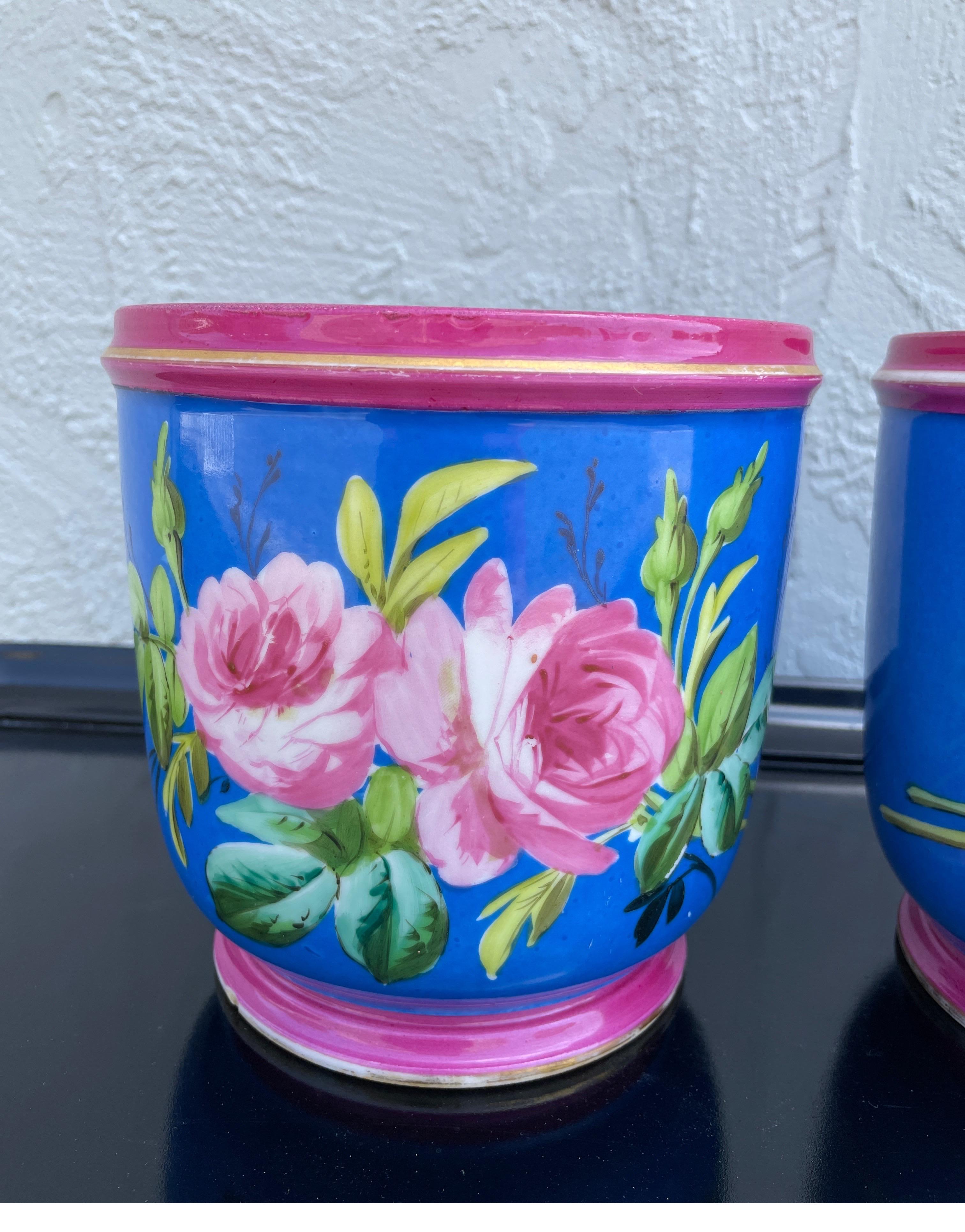 Beautiful pair of Paris Porcelain Cachepots depicting large pink peonies on a brilliant blue background. Paintings are well executed & colors are still vibrant.
These elegant planters will add panache to any setting.