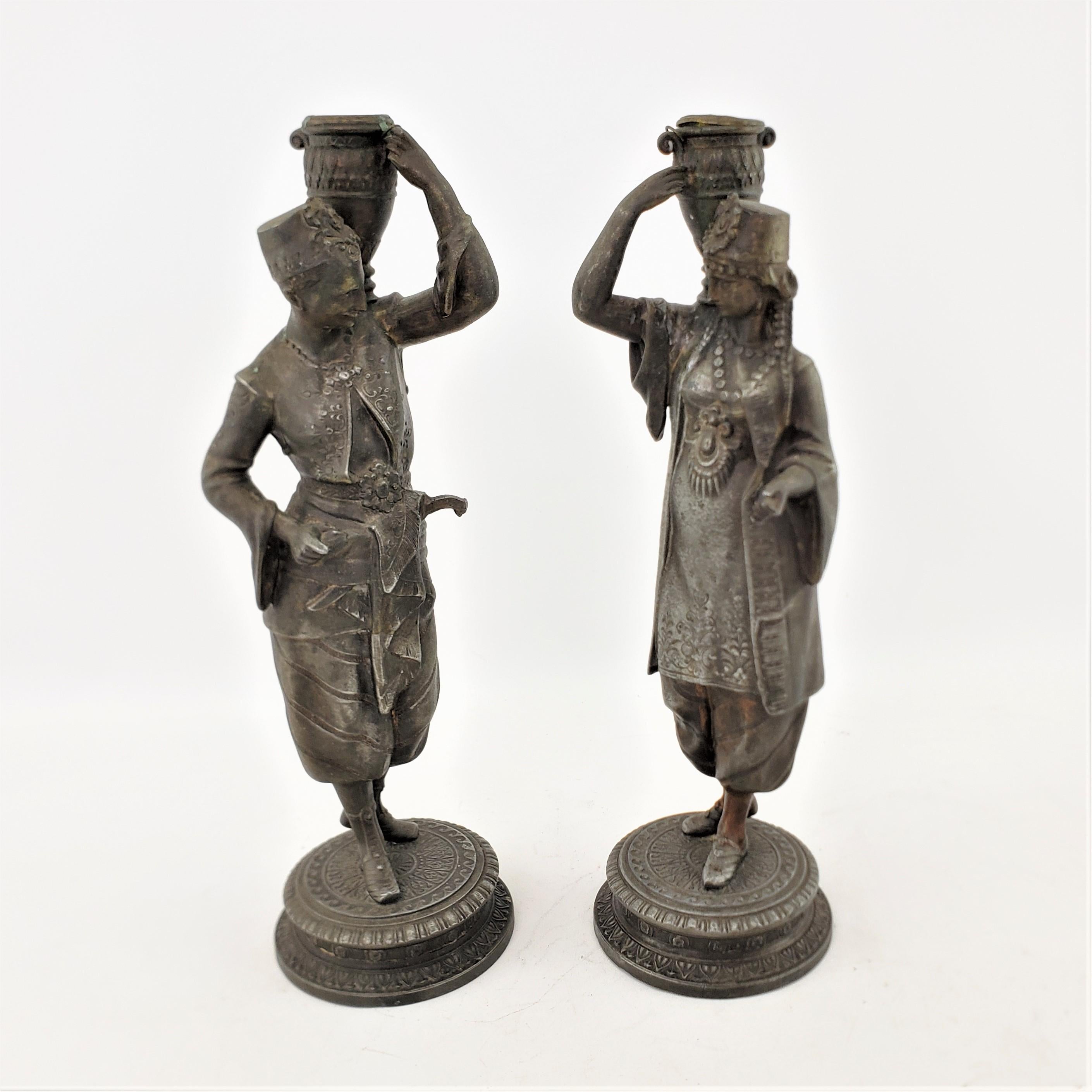 Austrian Pair of Antique Patinated Spelter Candlesticks of a Man & Woman Carrying Water For Sale