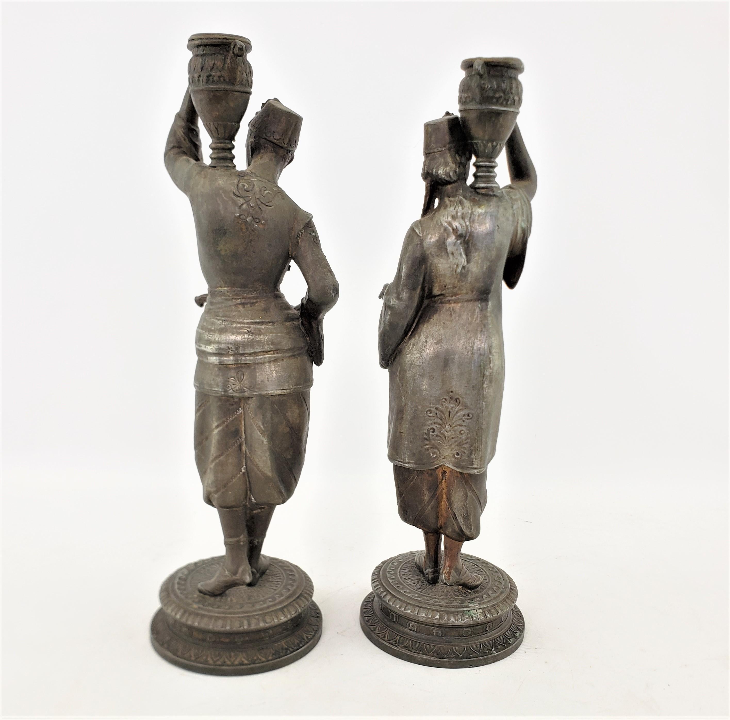 Pair of Antique Patinated Spelter Candlesticks of a Man & Woman Carrying Water In Good Condition For Sale In Hamilton, Ontario