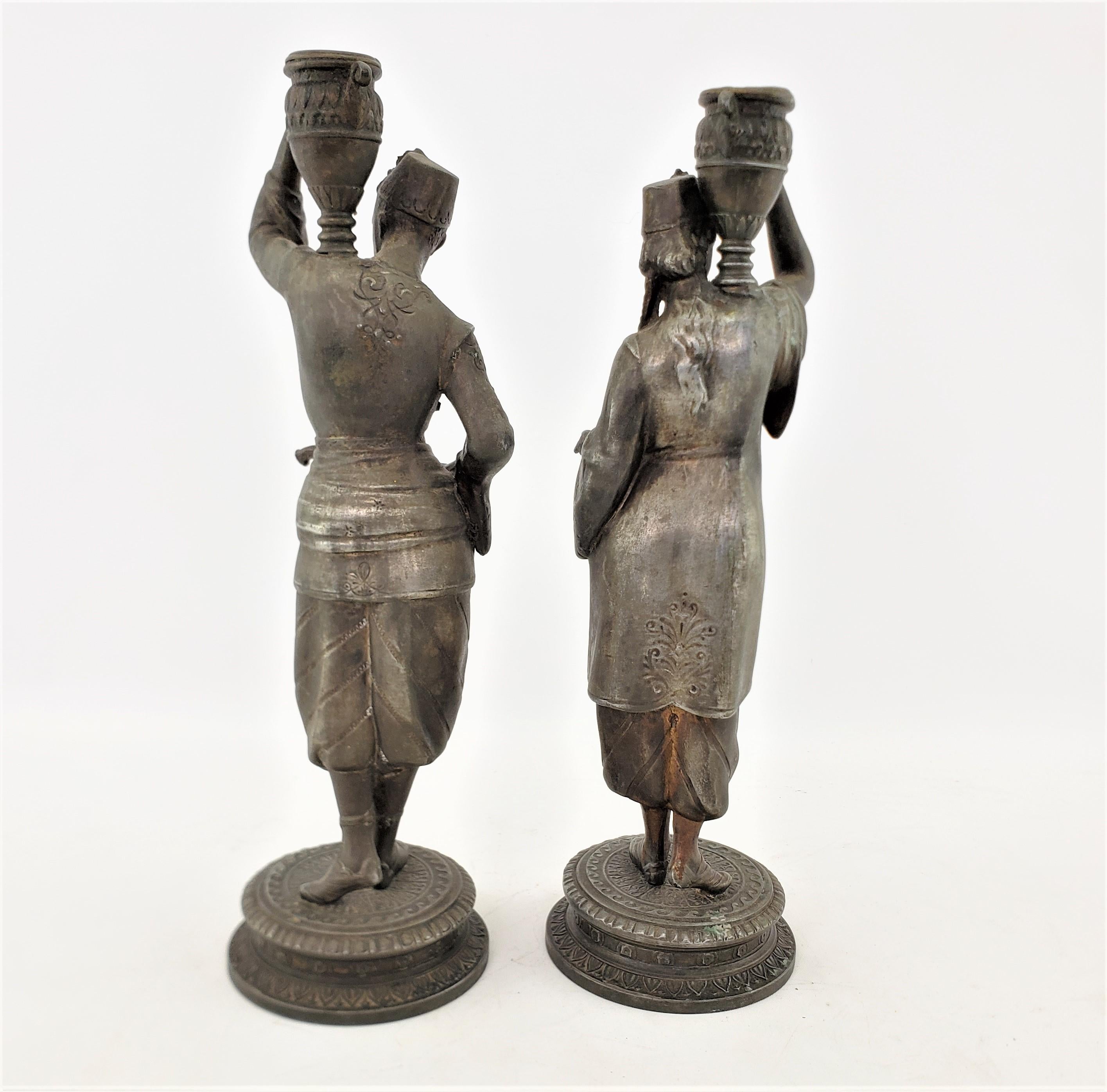 Coppia di antichi candelabri in spelta patinata raffiguranti un uomo e una donna che trasportano acqua In condizioni buone in vendita a Hamilton, Ontario