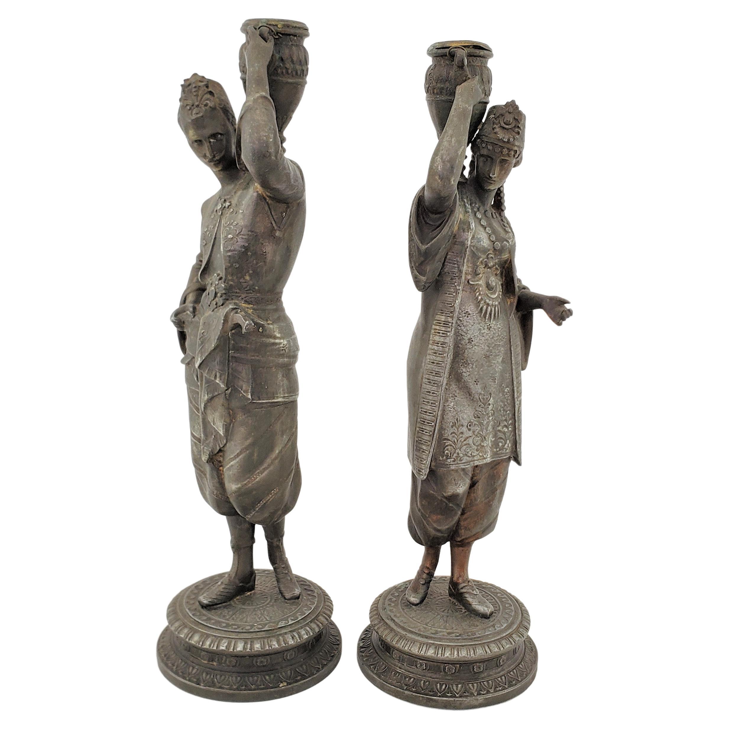 Pair of Antique Patinated Spelter Candlesticks of a Man & Woman Carrying Water