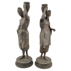 Pair of Antique Patinated Spelter Candlesticks of a Man & Woman Carrying Water