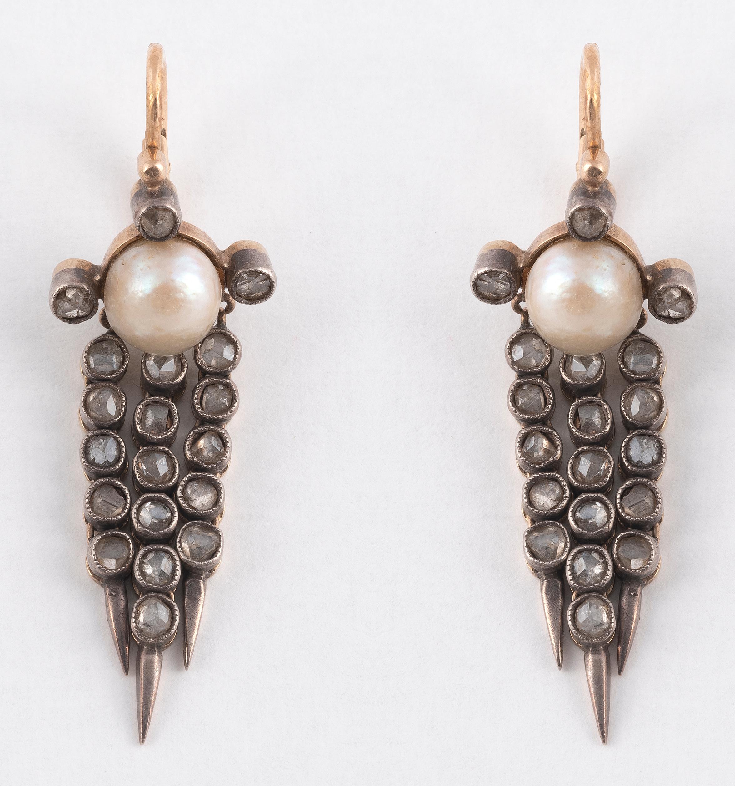 Each earring top featuring a natural pearl measuring approximately 7.00mm, with rose cut diamond-set fringe.
Lenght: 44mm
Weight: 6,8gr.
