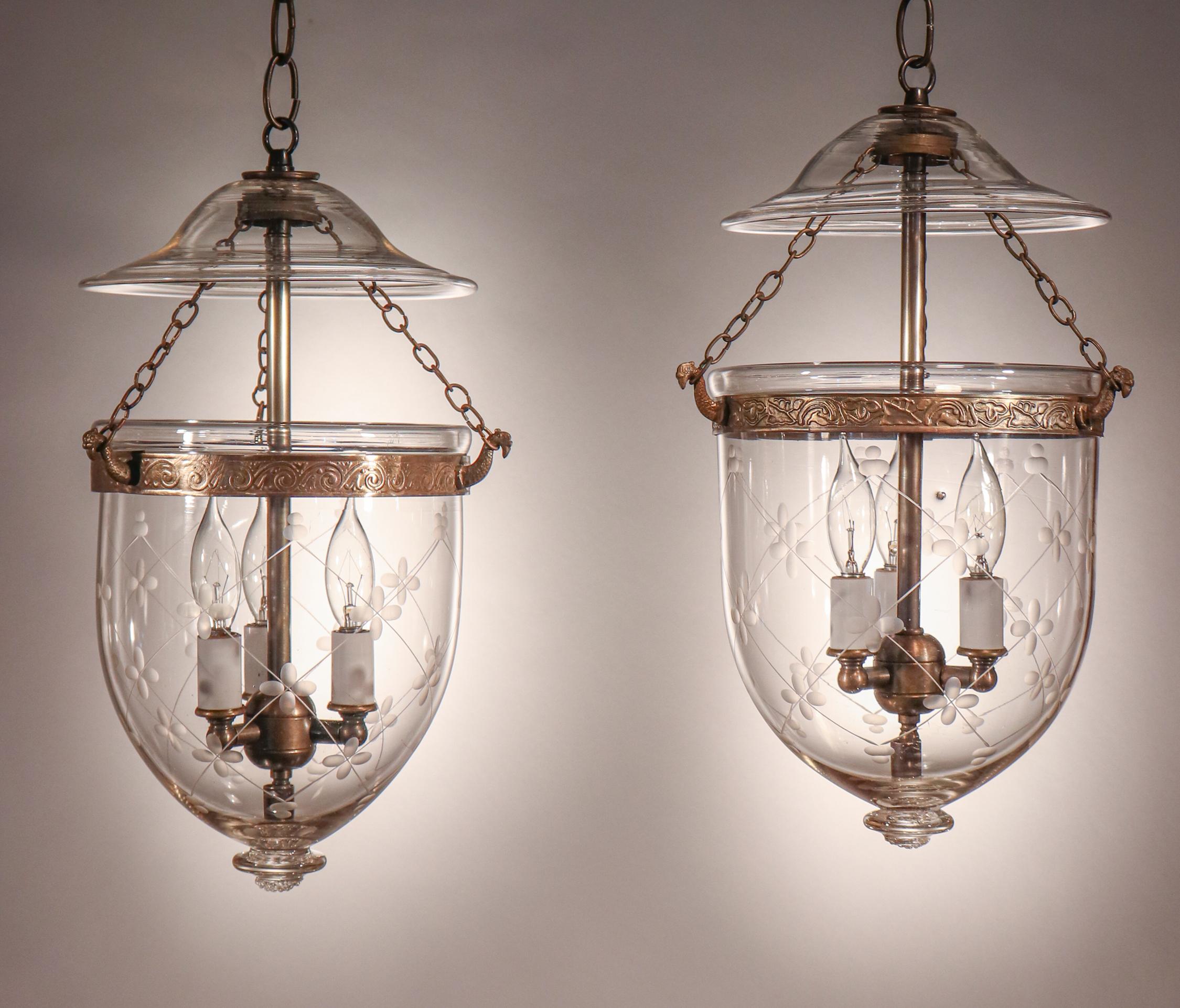 A rare, well-matched pair of petite English hand blown glass bell jar lanterns. Perfect for smaller spaces and/or lower ceiling heights, these circa 1890 pendants feature lovely form and a finely etched trellis motif. The brass bands, which have