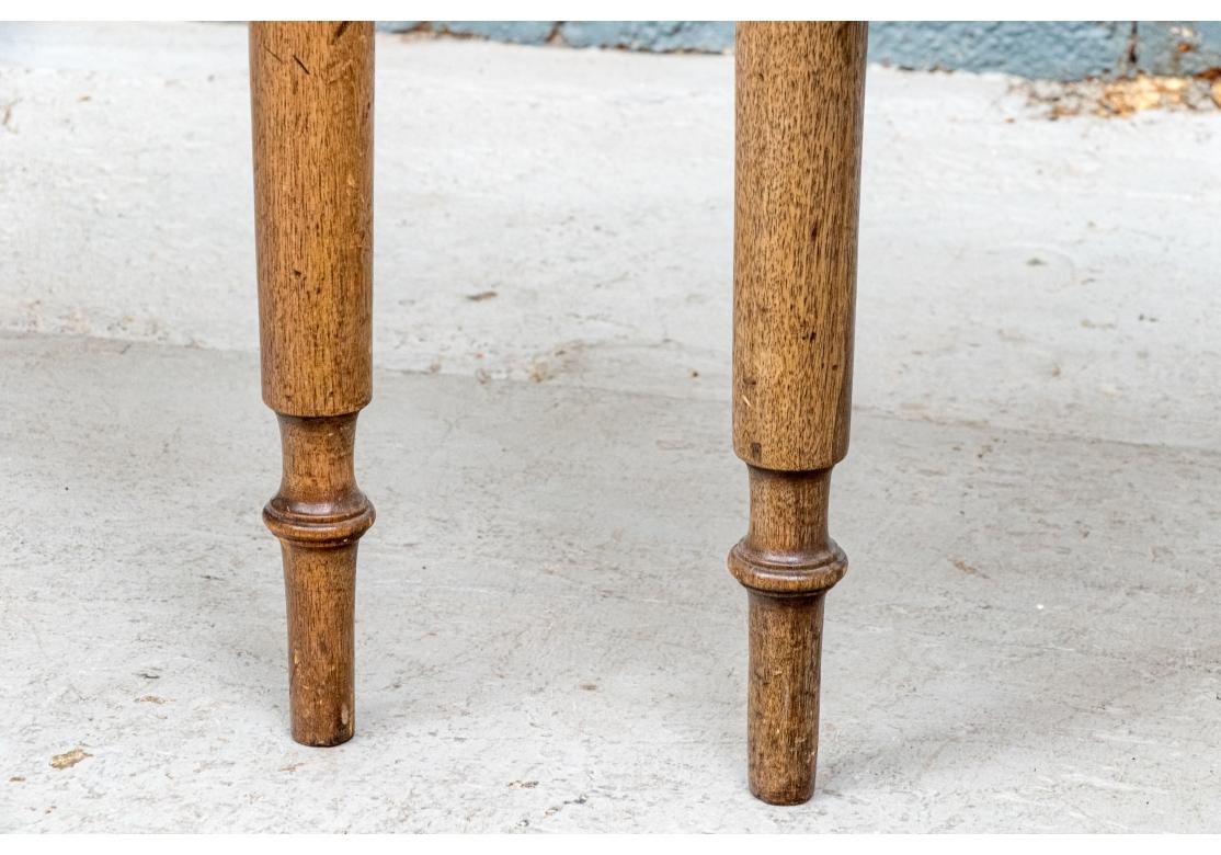 A pair of diminutive Antique pine Console Tables in Pine. Each demilune top table with undecorated deep aprons and raised on three carved legs with bulbous tops, ring details and tall cylindrical feet. 

Condition: Please review the detail photos.