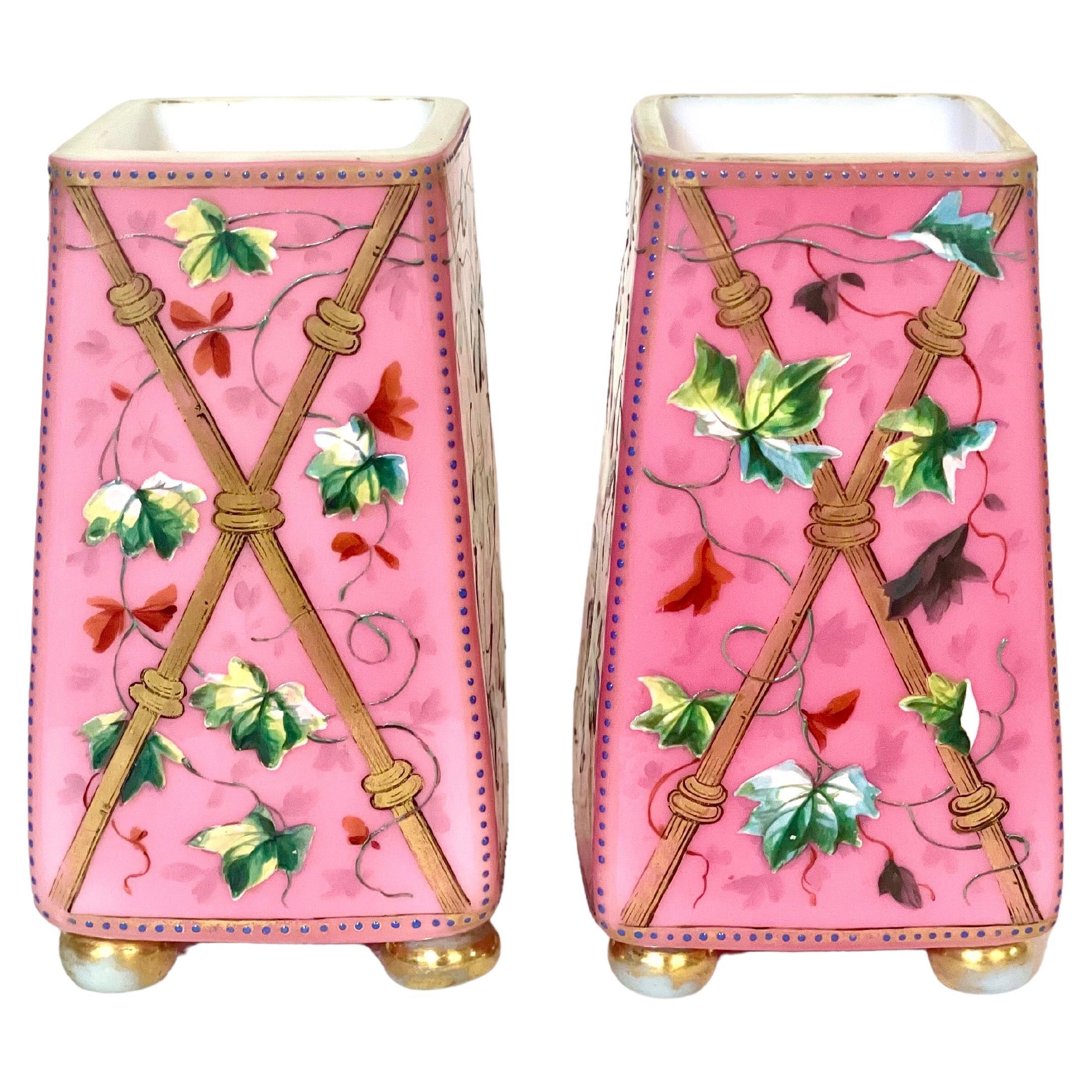 A pair of exquisite antique pink opaline vases, hand enamelled by an accomplished artist with a gloriously vivid and colourful design of garden birds and entwining leaves on a background of crossed bamboo canes on all four faces. There is some