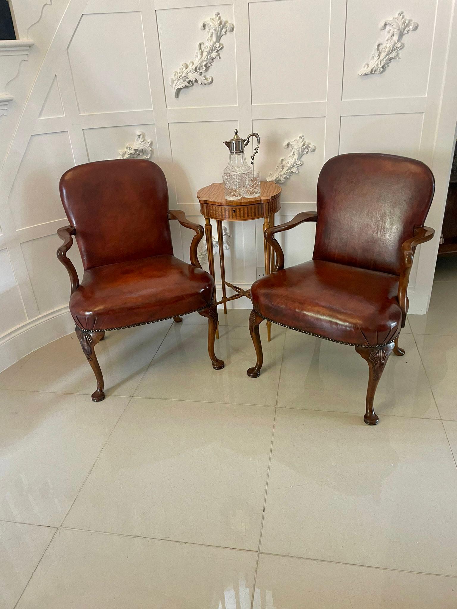 Pair of antique quality leather and carved walnut desk chairs having newly reupholstered seats and backs in a quality chestnut colour leather, shaped open arms with shaped supports standing on shaped carved walnut cabriole legs with pad feet out