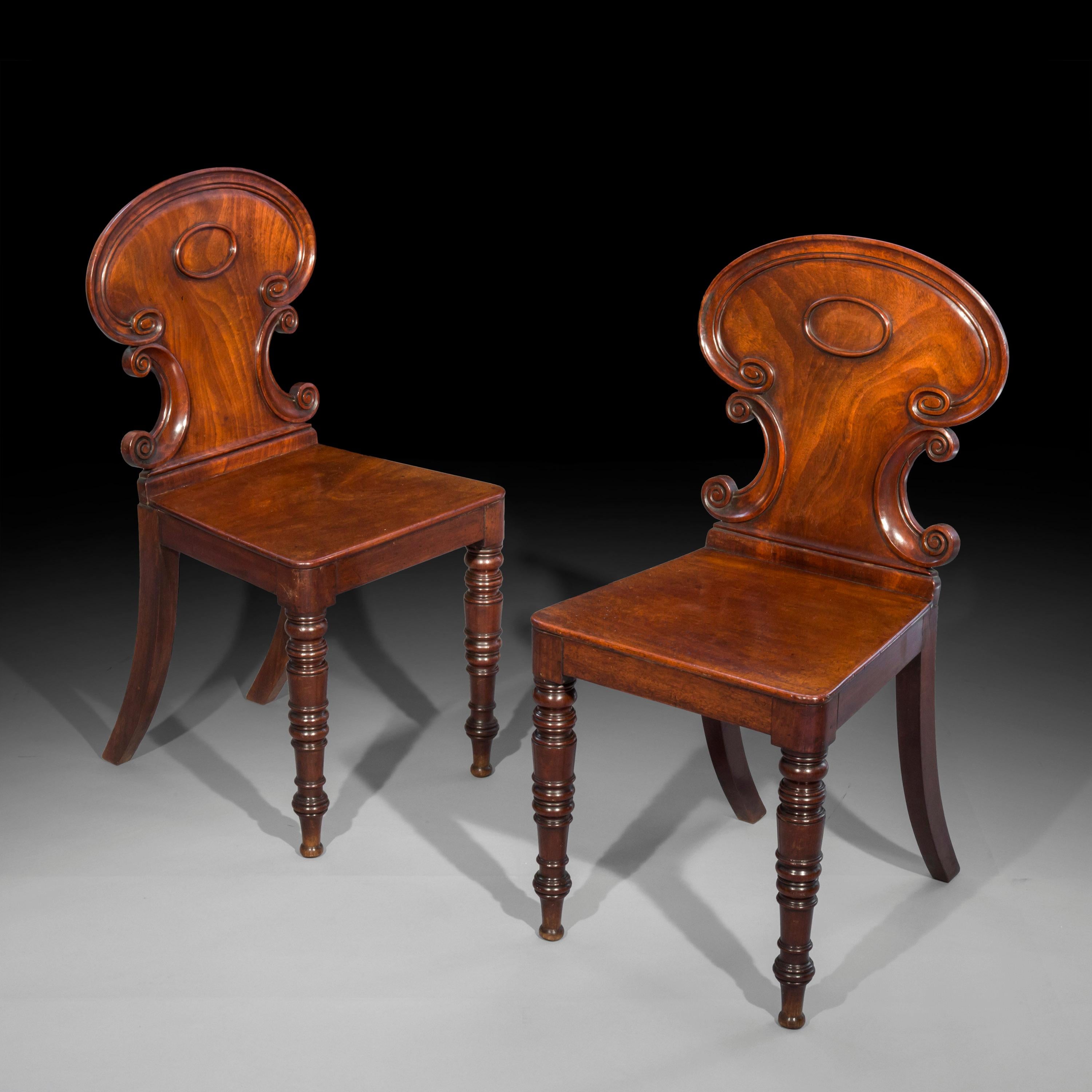 A very fine and elegant pair mahogany hall chairs of the Regency period, in the style of Gillows of Lancaster and London,
England, circa 1820.

Why we like them
Particularly rare design, with finely carved cartouche backs, essentially a more