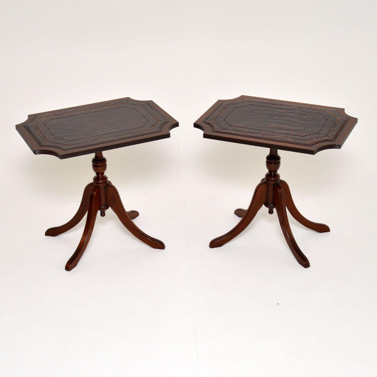 Pair of antique Regency style side tables with original tooled leather tops & in good original condition, dating from circa 1950s period.

They have curved corners on the tops which have reeded edges. The turned baluster pedestals sit on quadruple