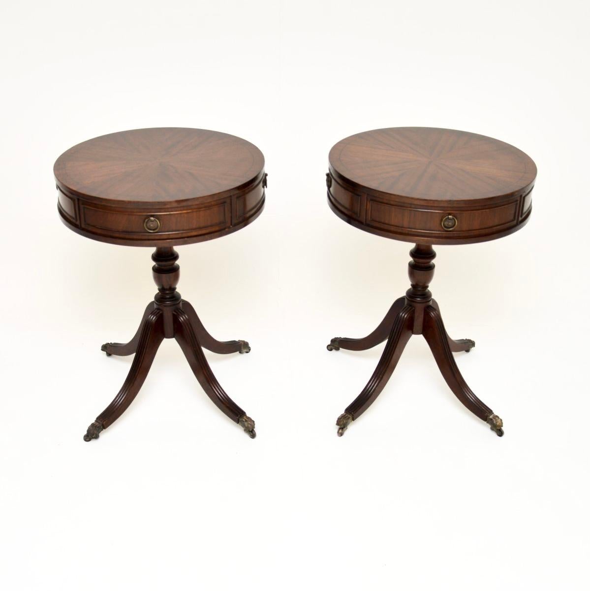 A smart and very useful pair of antique Regency style side tables. They were made in England, they date from around the 1950’s.

The drum shaped circular tops have a drawer on each side and lovely grain patterns. They stand on splayed bases with