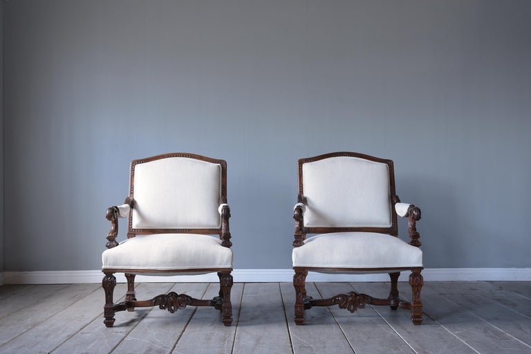An extraordinary pair of antique renaissance armchairs in excellent condition beautifully crafted out of walnut wood and has been professionally restored by our expert craftsmen team. This pair of lounge chairs features its original walnut color