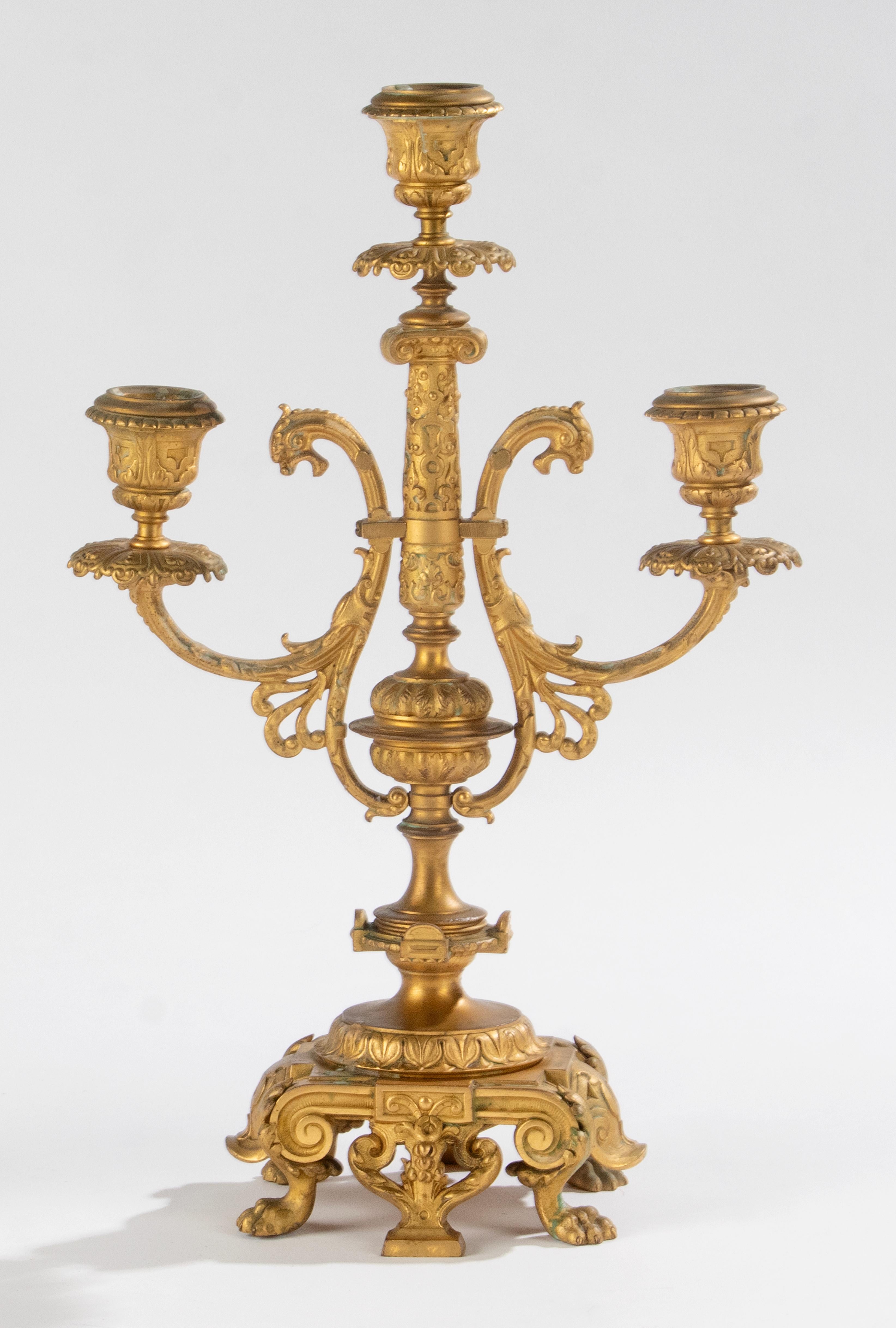 A fine pair of French candelabras, made of fire-gilt bronze, in Renaissance style. Each candlestick has three candleholders. This pair of candelabra's are original for a fire mantel. Not very deep, and the candle holders are different in height, for