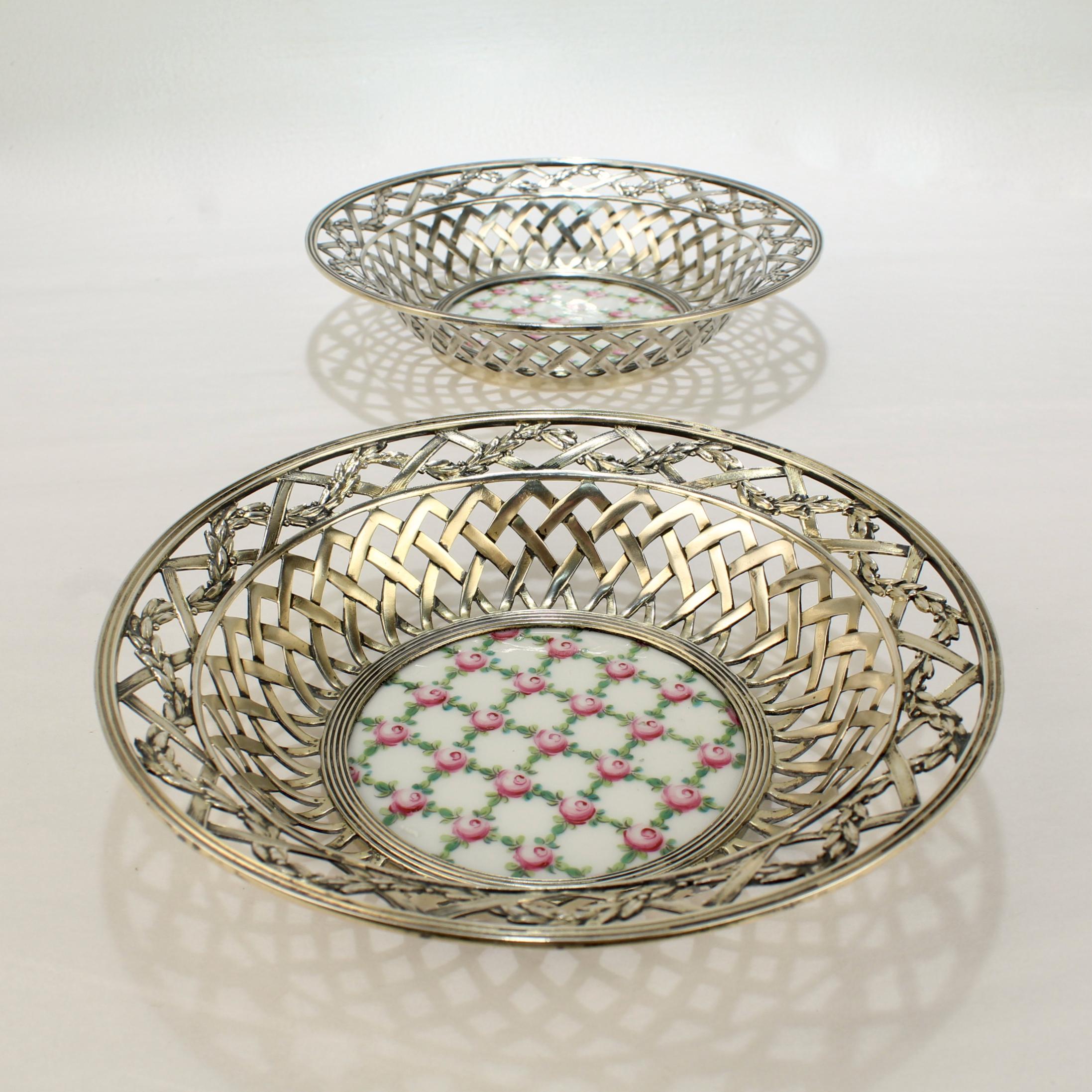 A fine pair of associated reticulated .935 sterling silver bowls.

Each with a round Sevres-type porcelain insert at the base, basketweave design, and intertwined garland and ribbon border. 

The porcelain plaques or inserts have a lattice pattern