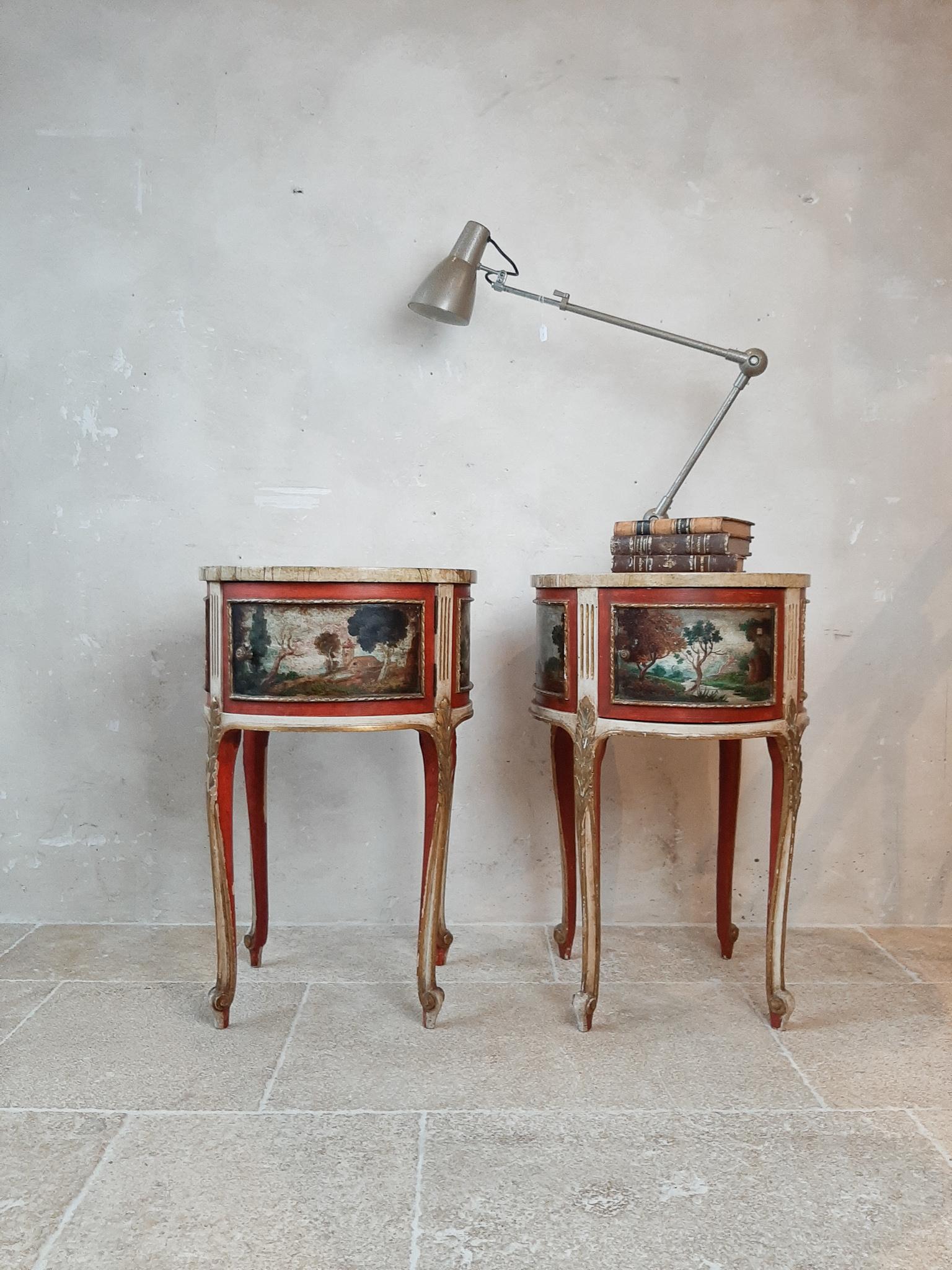 A pair of antique round Italian bed stands / bedside tables / side table / end tables, with hand painted scenes of landscapes all around. Beautiful gold and ivory white patina with red accents and a marbled wooden top. At the front of the side