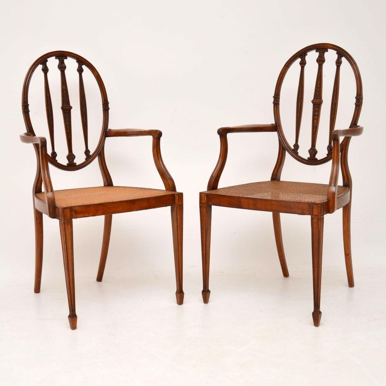 Very elegant & fine quality pair of antique Edwardian Satinwood armchairs of Sheraton design, dating from the 1900-10 period & in excellent condition.

They have oval backs, with intricately carved upright bars & cane seats that are also in good