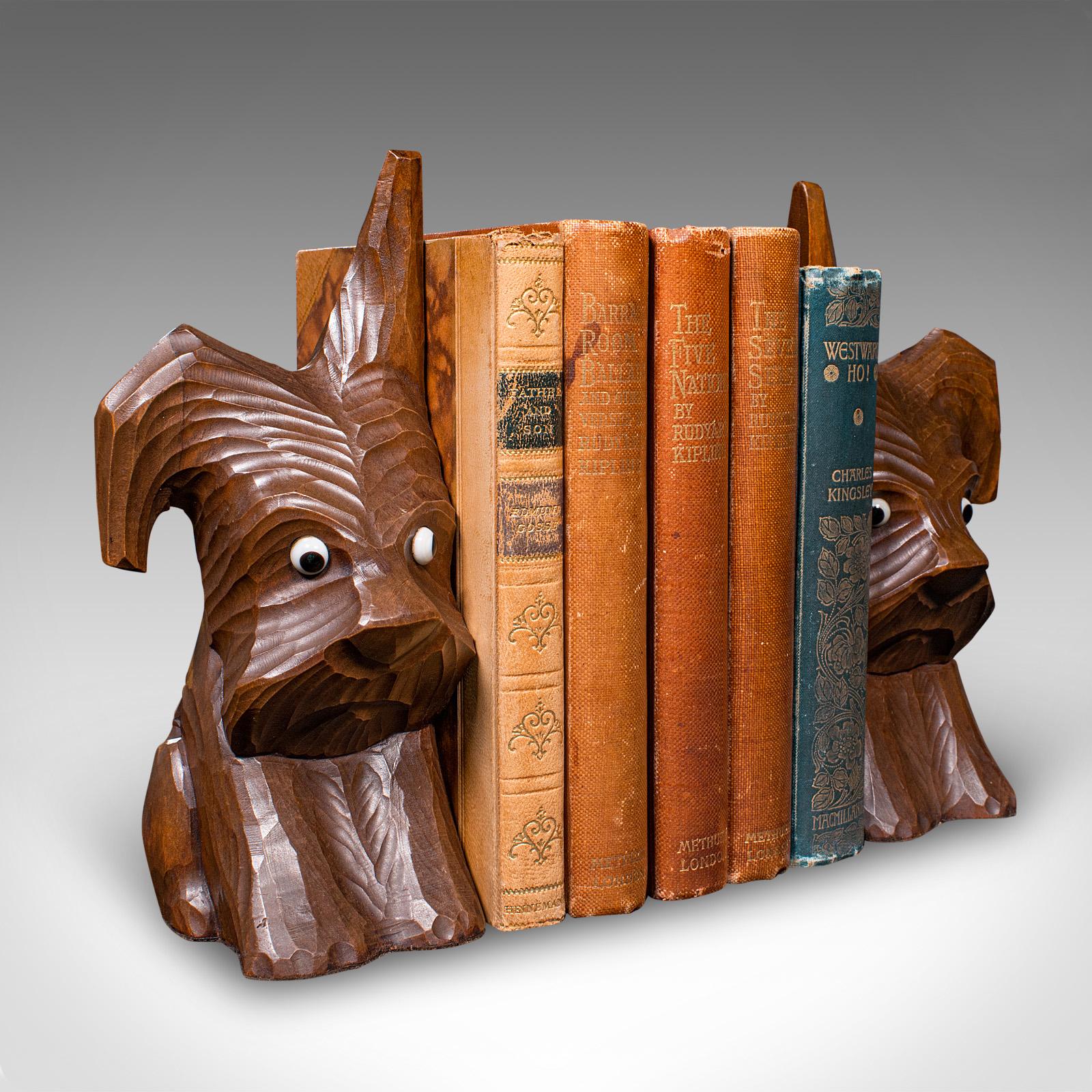 This is a delightful pair of antique Scottie dog bookends. An English, figural book rest in beech, dating to the Edwardian period, circa 1910. Brimming with charm, these decorative figures offer a playful accent to any shelf or mantel.

Pleasingly