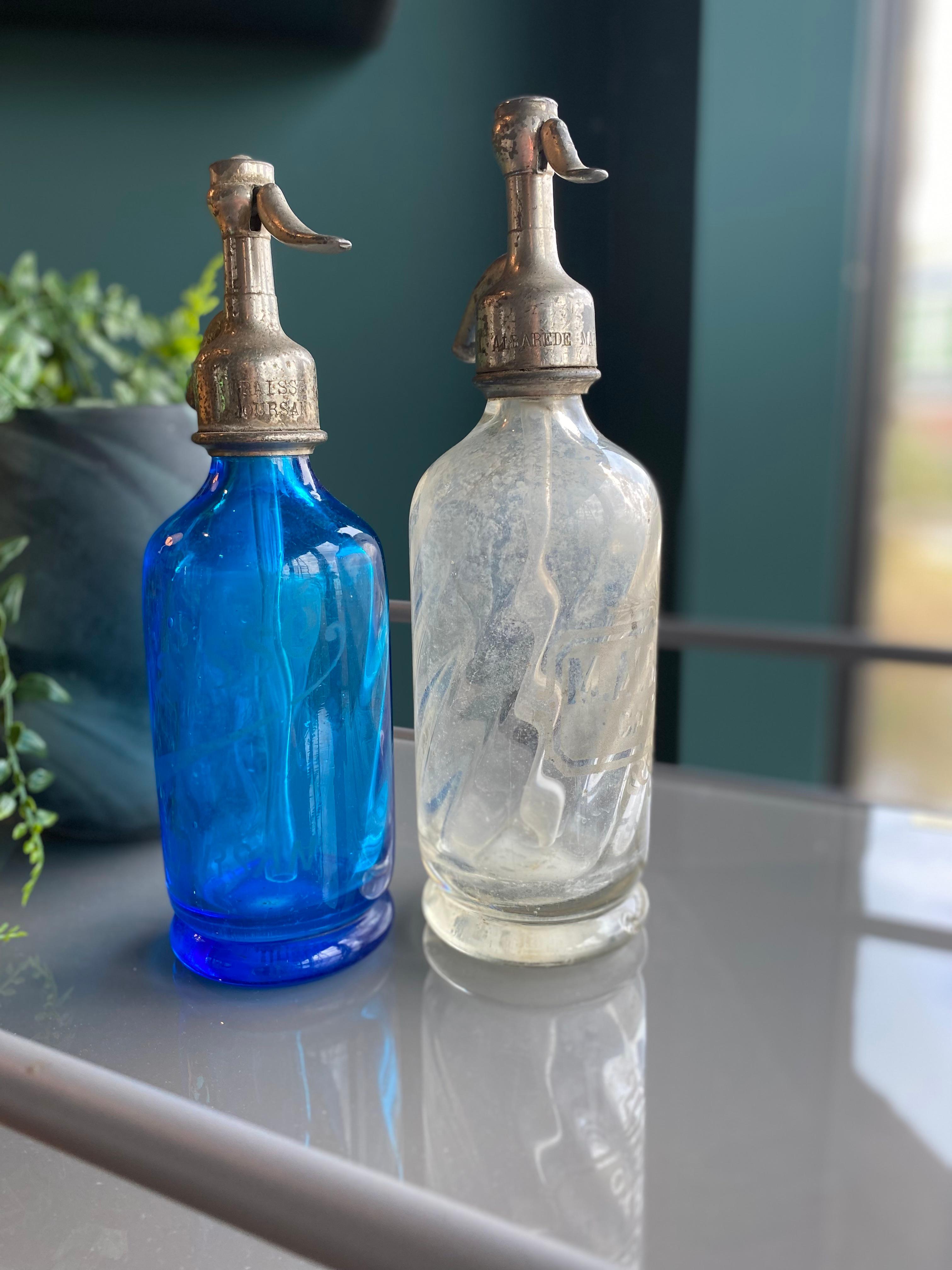 Antike kleine Siphons aus Frankreich aus den Jahren um 1900. 
Die kleinen Flaschen sind selten und nicht leicht zu finden. Die normale Größe ist 30cm und sie haben 24cm.
Die Flaschen sind aus dickem, schwerem, blau-weißem Glas und die Verschlüsse