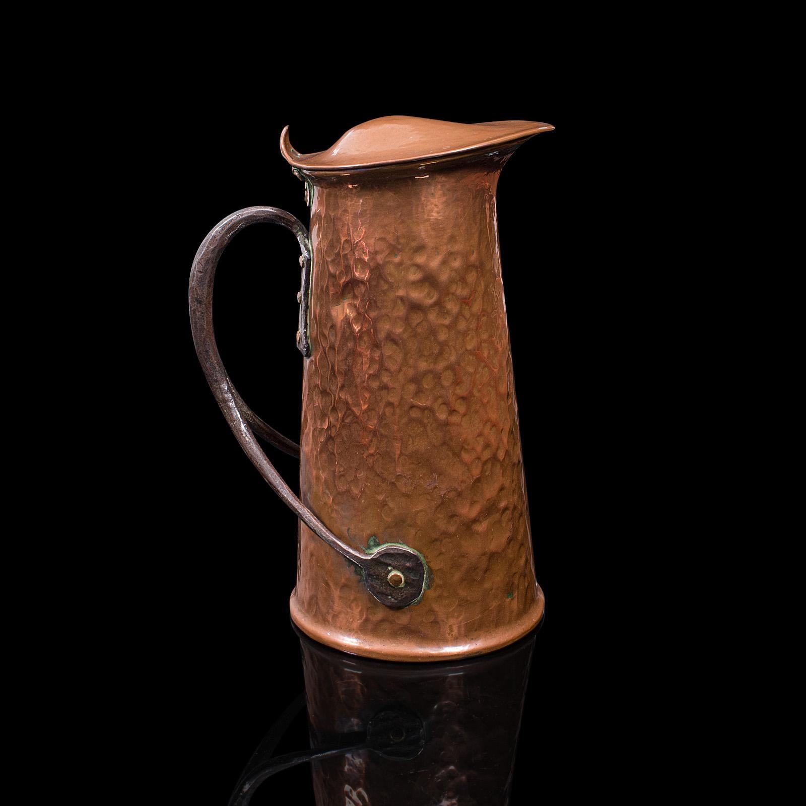 This is a rare pair of antique serving jugs. An English, hand-forge copper ewer with Arts & Crafts taste, dating to the late Victorian period, circa 1900.

Wonderful hand-crafted appeal with strong Arts & Crafts taste
Displaying a desirable aged