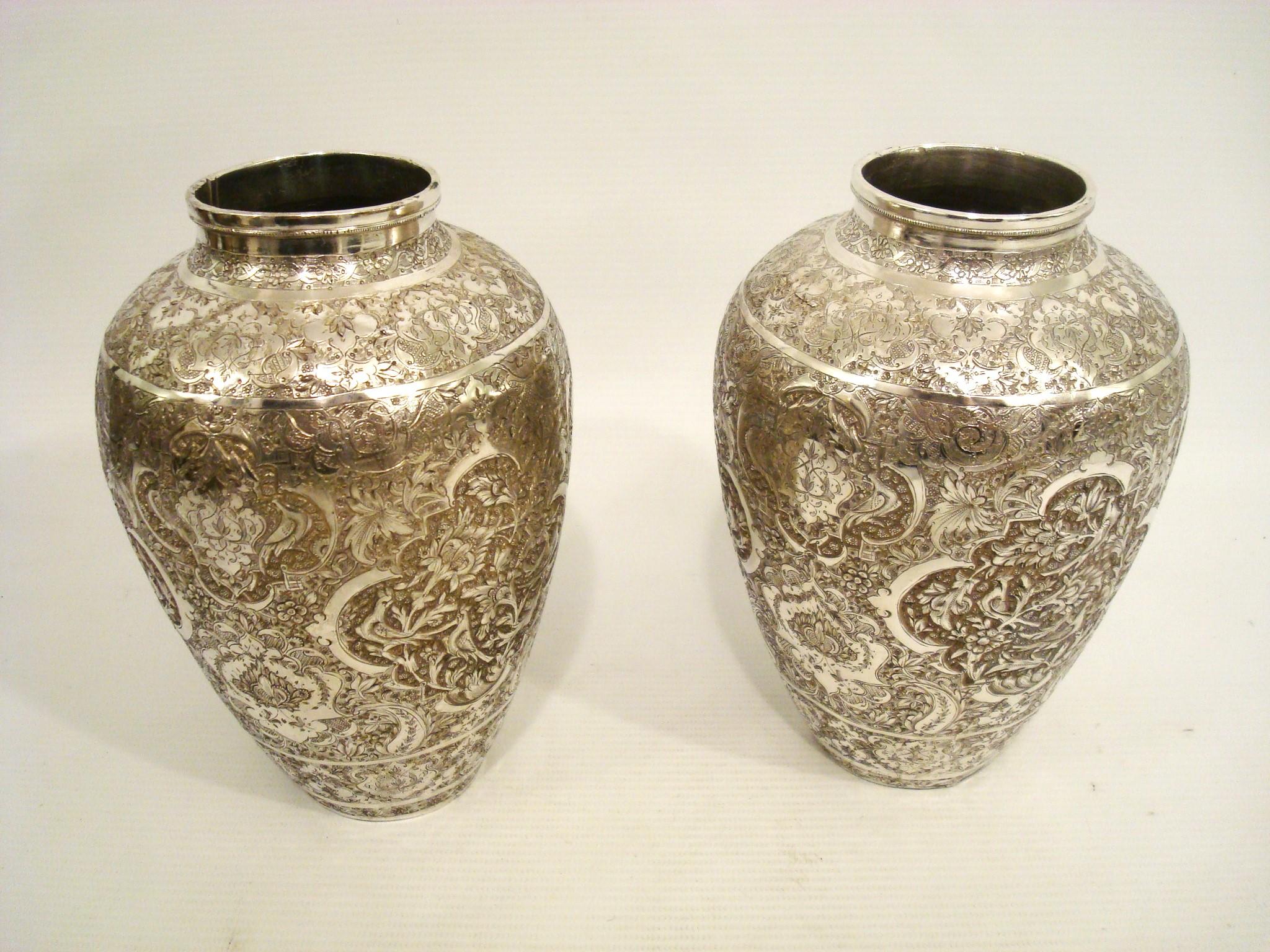 Una bella coppia di vasi islamici in argento.
Riccamente decorato con decorazioni repousse in stile Ishafan (Eshafan) che includono teste di grifone, fiori e viti, uccelli del paradiso, fogliame e decorazioni geometriche arabescate.
Firmato alla