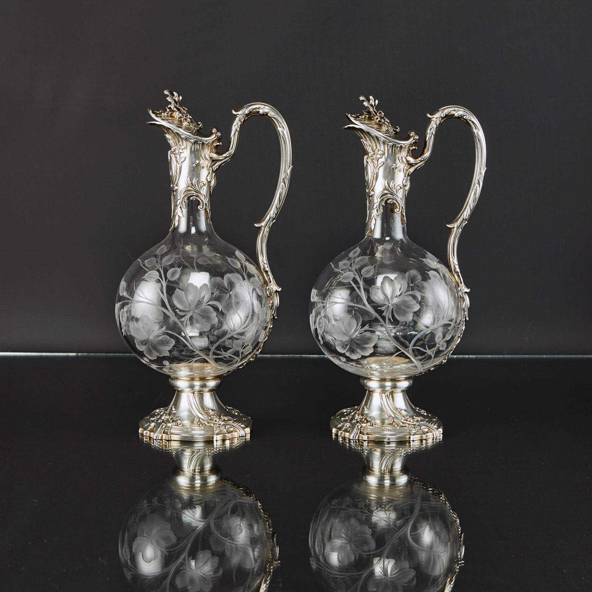Pair of gorgeous late-19th-century antique silver and etched glass wine jugs in the Louis XV style. The baluster-shaped glass bodies are delicately hand engraved in fine detail showing branches of leaves and blossoms.

The 1st quality (.950)