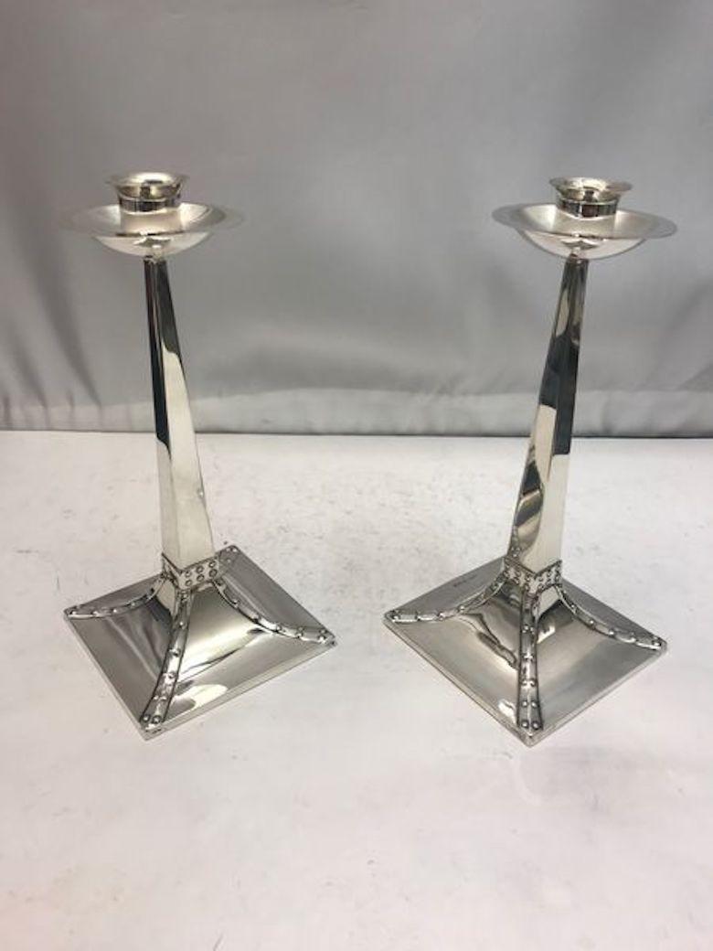 A pair of candlesticks made in Sheffield, UK in 1922 by J Dixon. Designed with wax catcher and decorative square bases.
 