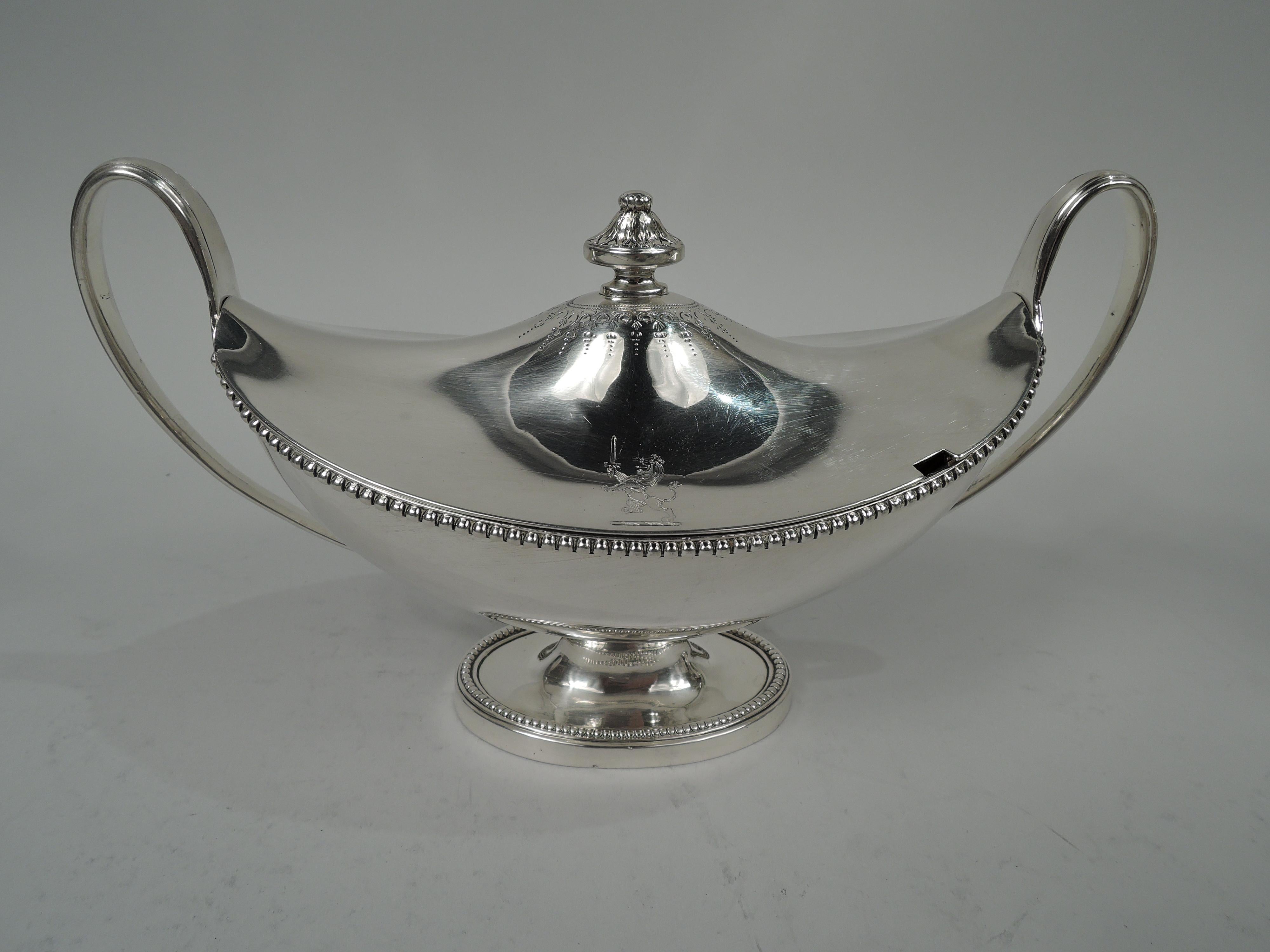 Pair of George III sterling silver tureens. Made by William Pitts in London in 1785. Each: Ovoid body with upturned ends on oval foot; high looping tapering and leaf-mounted end handles. Cover raised with leaf-capped vasiform finial in pointille and