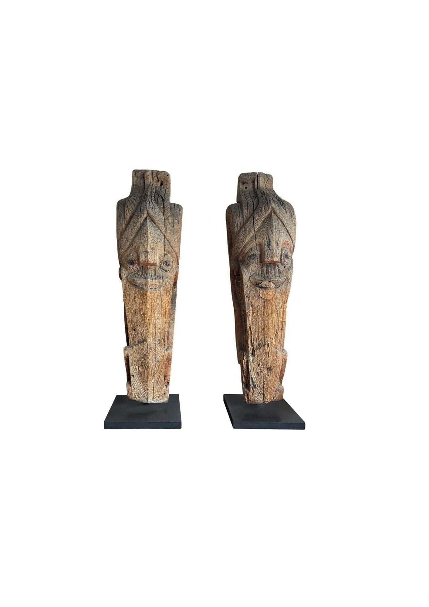 Montée sur un socle en métal peint en noir, cette paire de sculptures anciennes Singa provient de la tribu Batak de Sumatra. Chaque pièce est sculptée dans un seul bloc de bois et présente le motif protecteur emblématique Singa, une créature