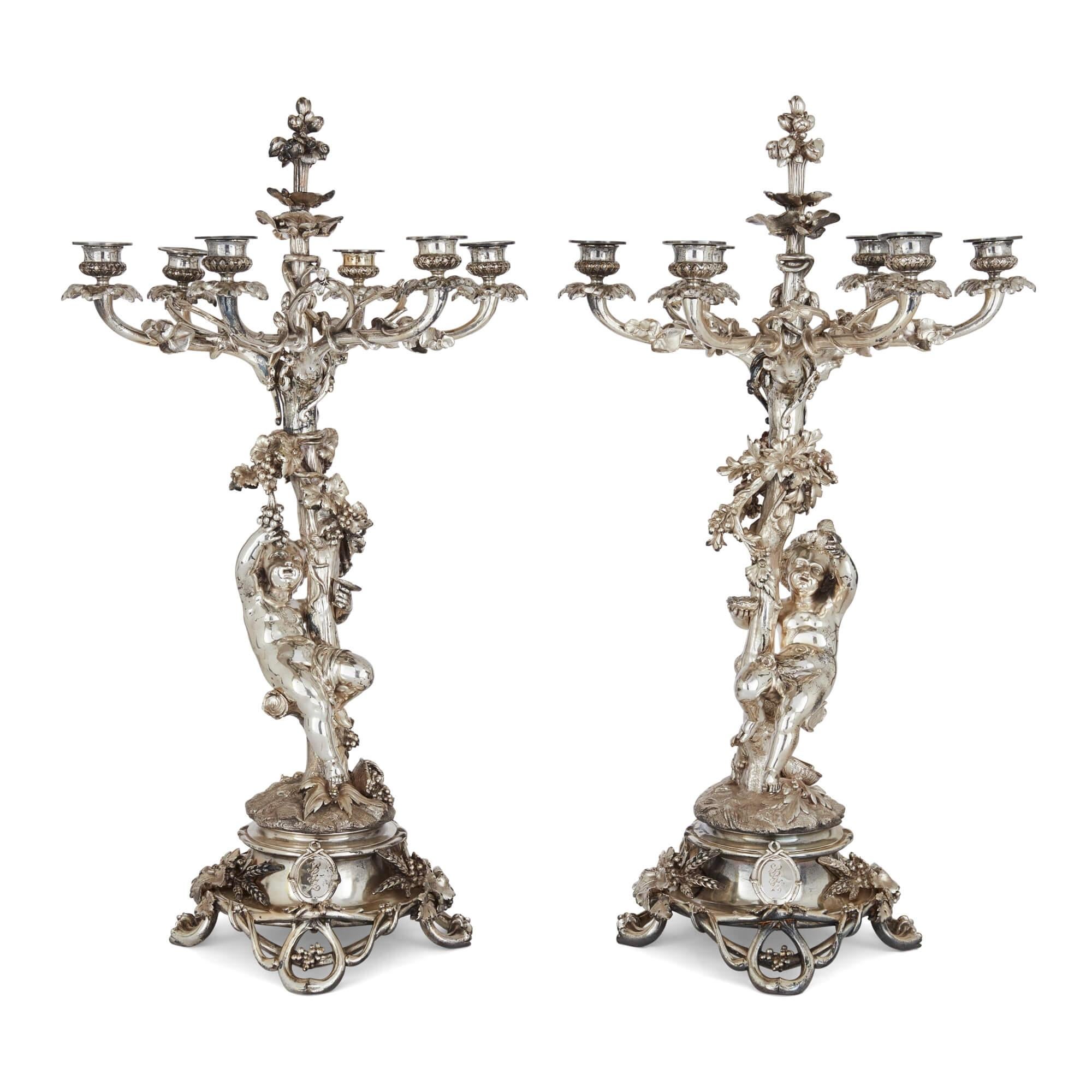 Pair of antique six-light silvered bronze candelabra by Christofle
French, 19th Century
Height 67cm, diameter 37cm

This superb pair of silvered bronze candelabra are crafted in the Rococo style. The circular bases stand on four openwork grapevine